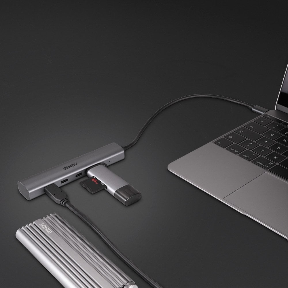 Laptop collegato a un hub LINDY argentato con altre unità e cavi collegati.