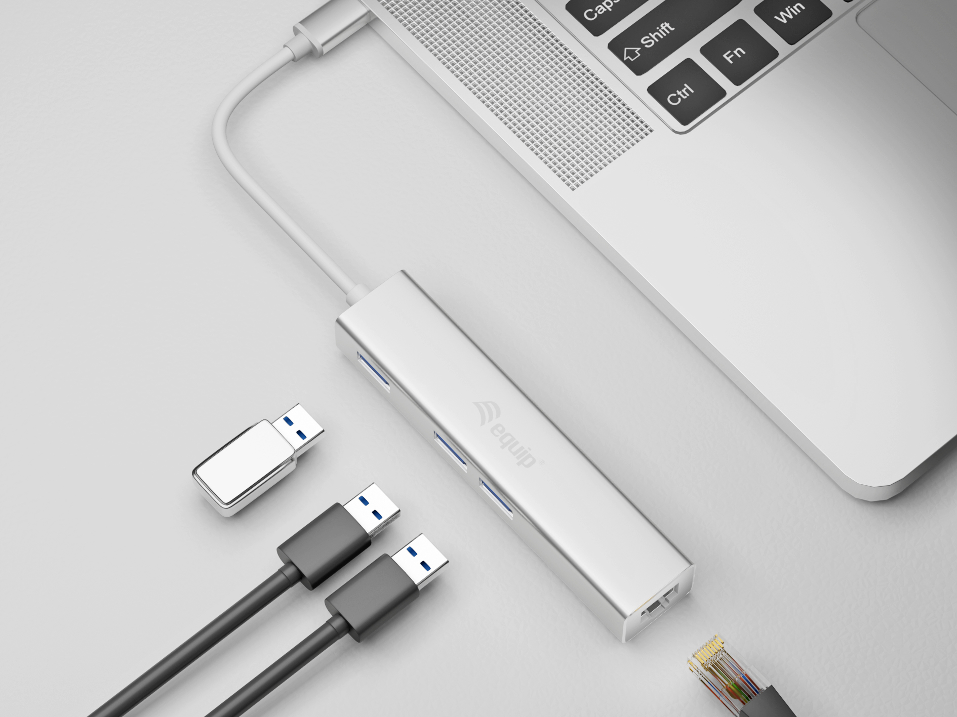 Hub USB argentato collegato a un laptop, con cavi e un altro dispositivo USB.