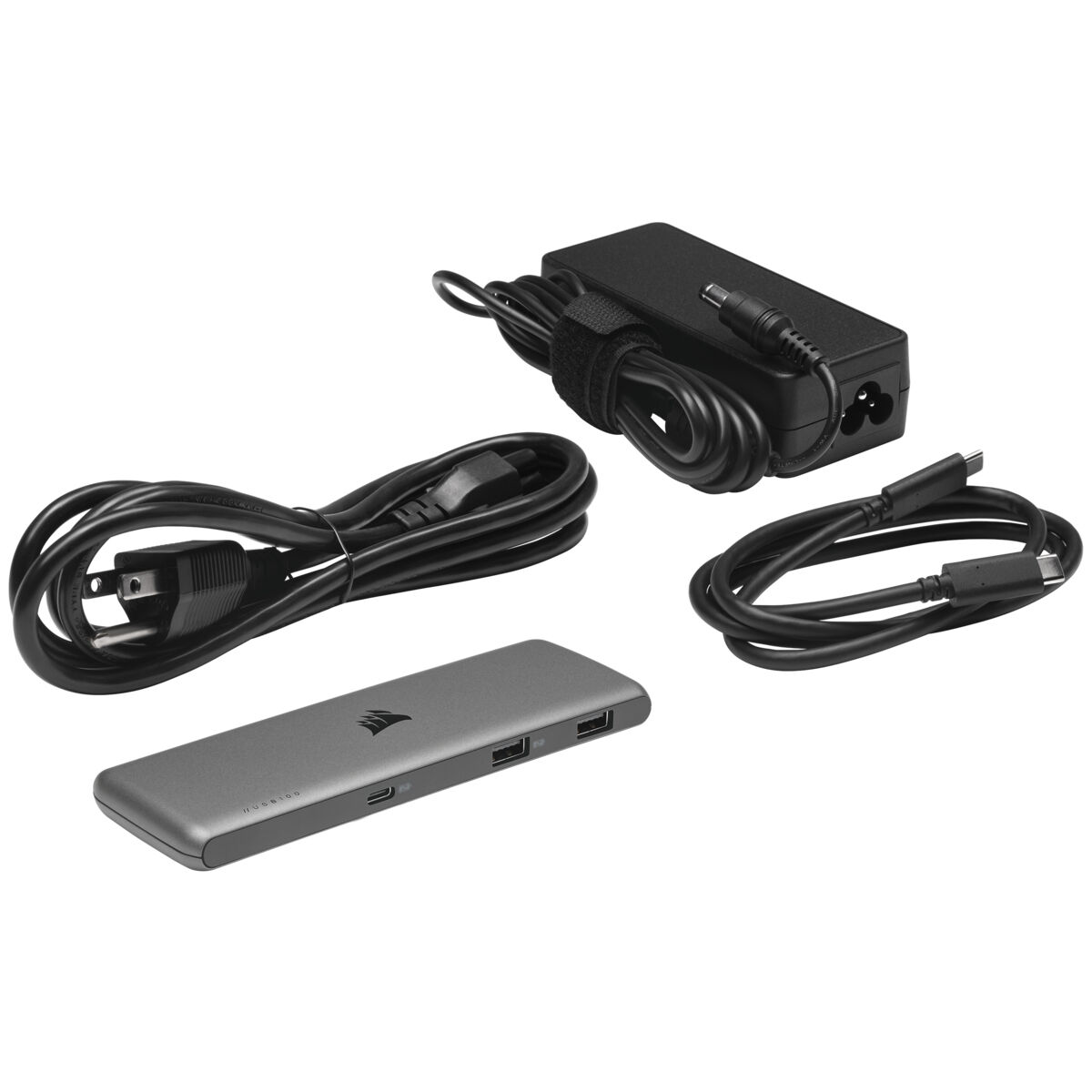 Componenti di un setup computer: adattatore di alimentazione, cavi e hub USB Corsair.