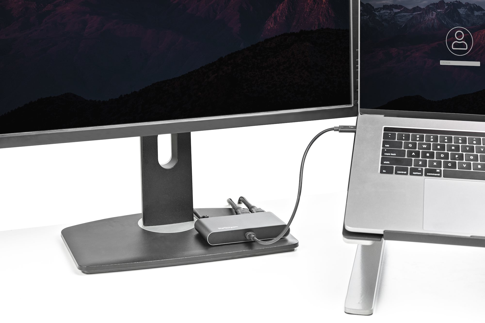 Un laptop collegato a un monitor tramite un hub. Sul monitor c'è una schermata di accesso.