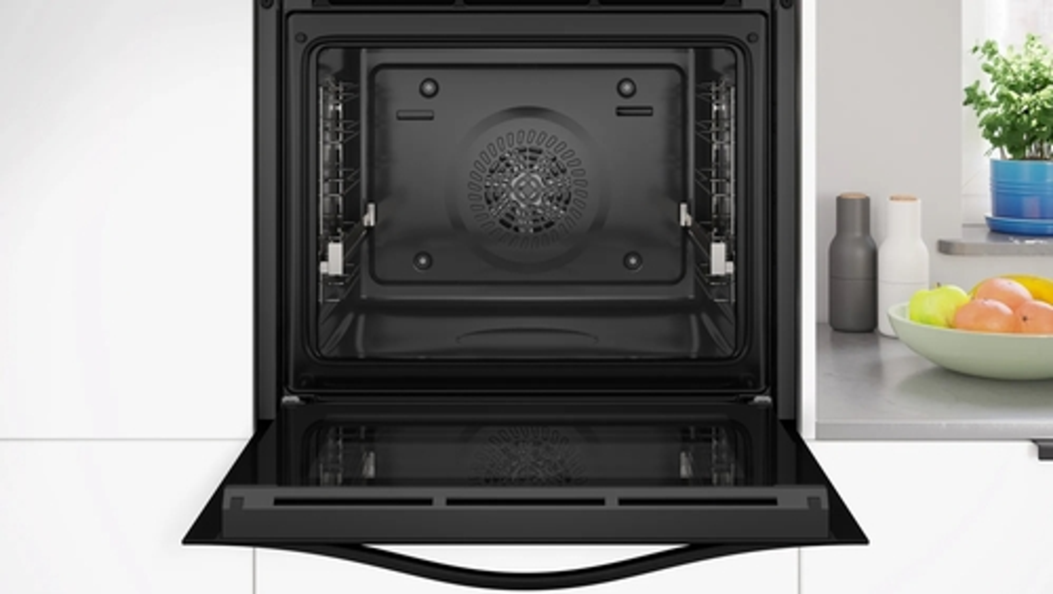Un interior de horno. Es negro con un ventilador y una luz.