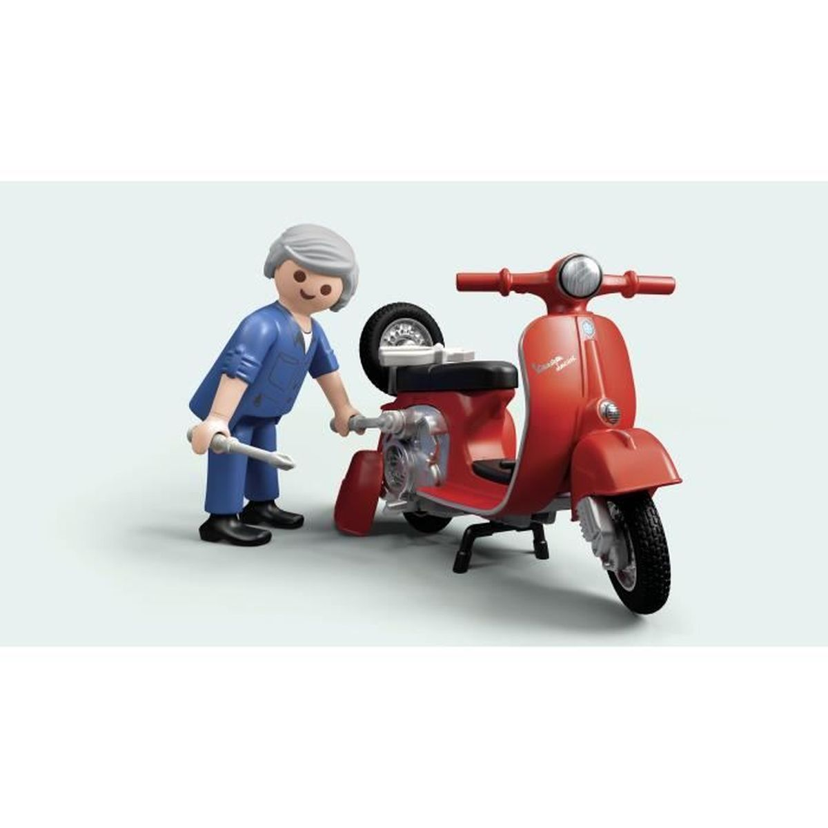 Figurka Playmobil naprawiająca czerwony skuter Vespa, z zapasową oponą w tle.