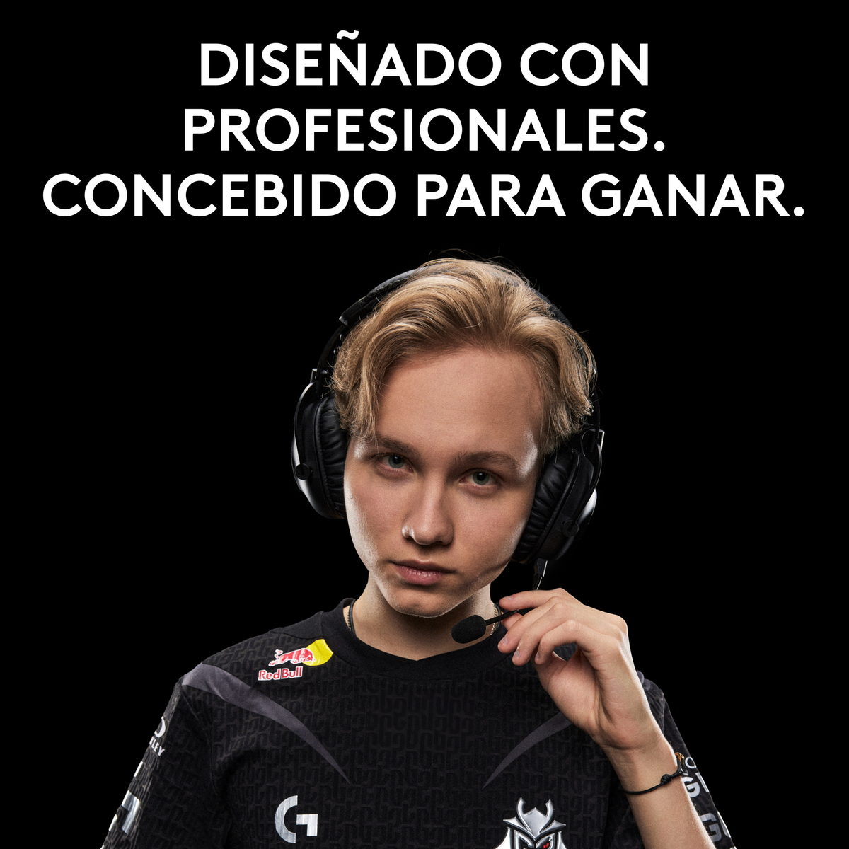 Młody mężczyzna w słuchawkach, pozujący na czarnym tle. Widoczne logo Red Bull.