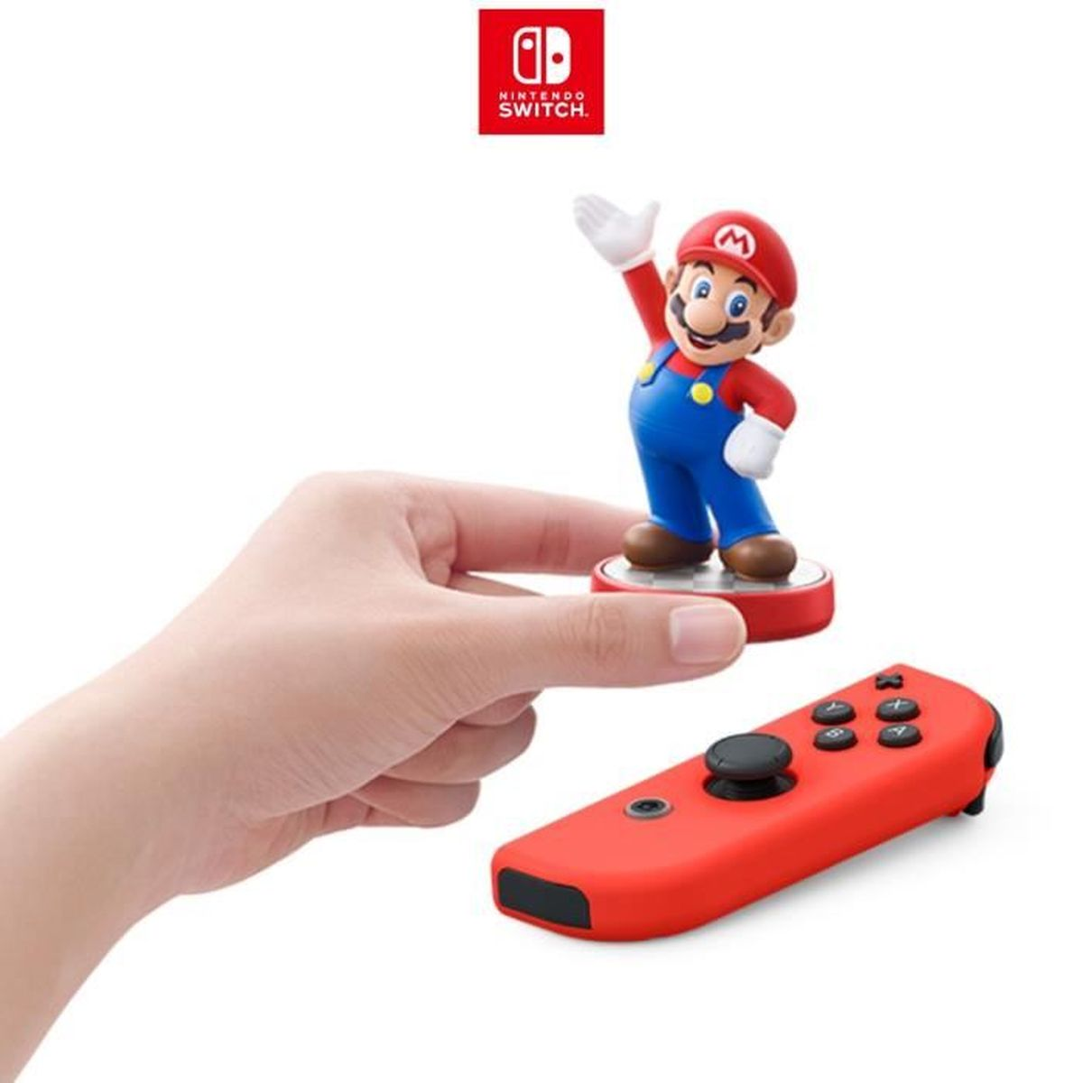 Osoba trzyma czerwony kontroler Nintendo Switch i figurkę Mario. Widoczne logo Nintendo Switch.