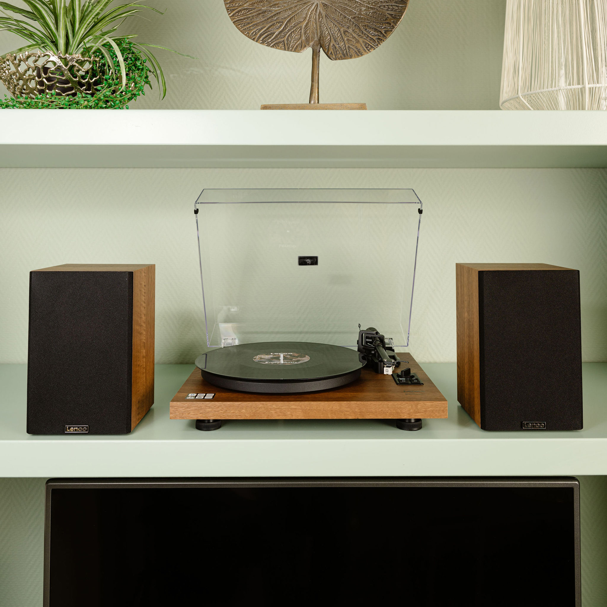 Turntable with speakers on a shelf. Wooden finish. Vinyl record playing.