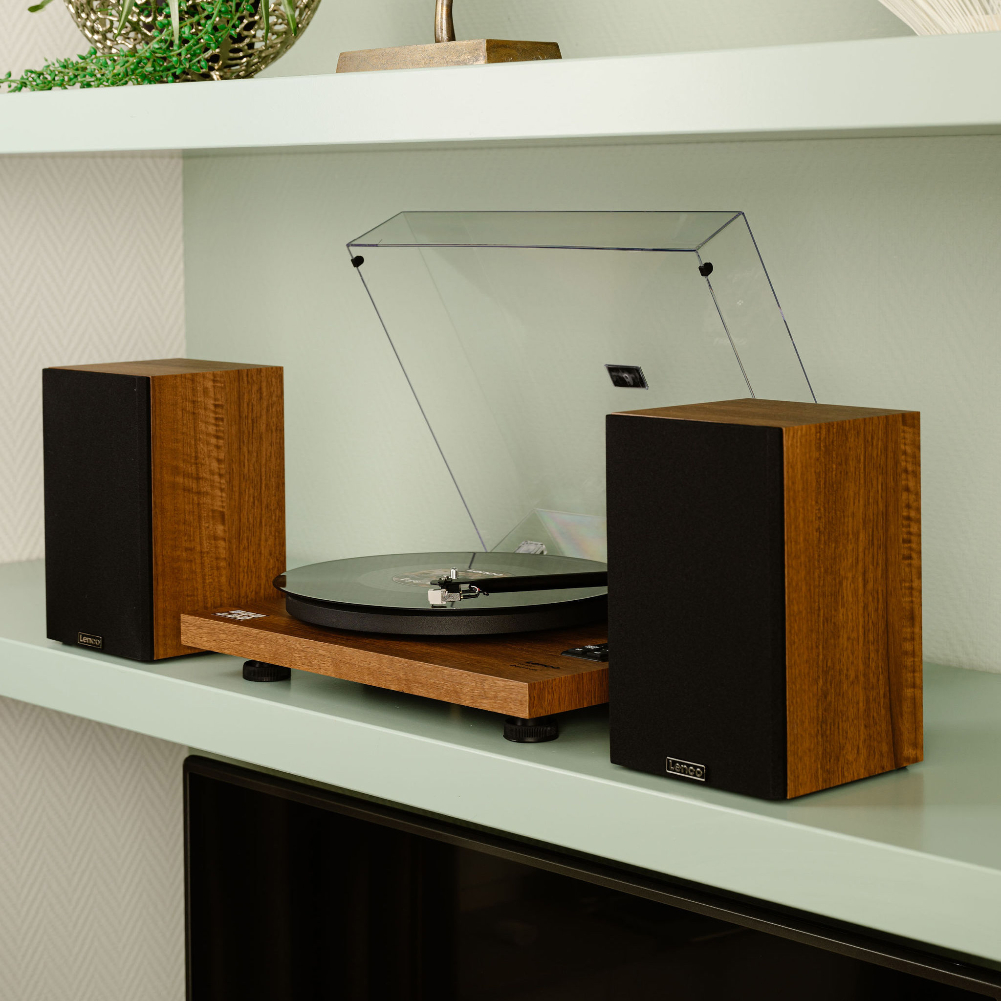 Turntable with speakers on a shelf. Wooden speakers and turntable with clear cover.