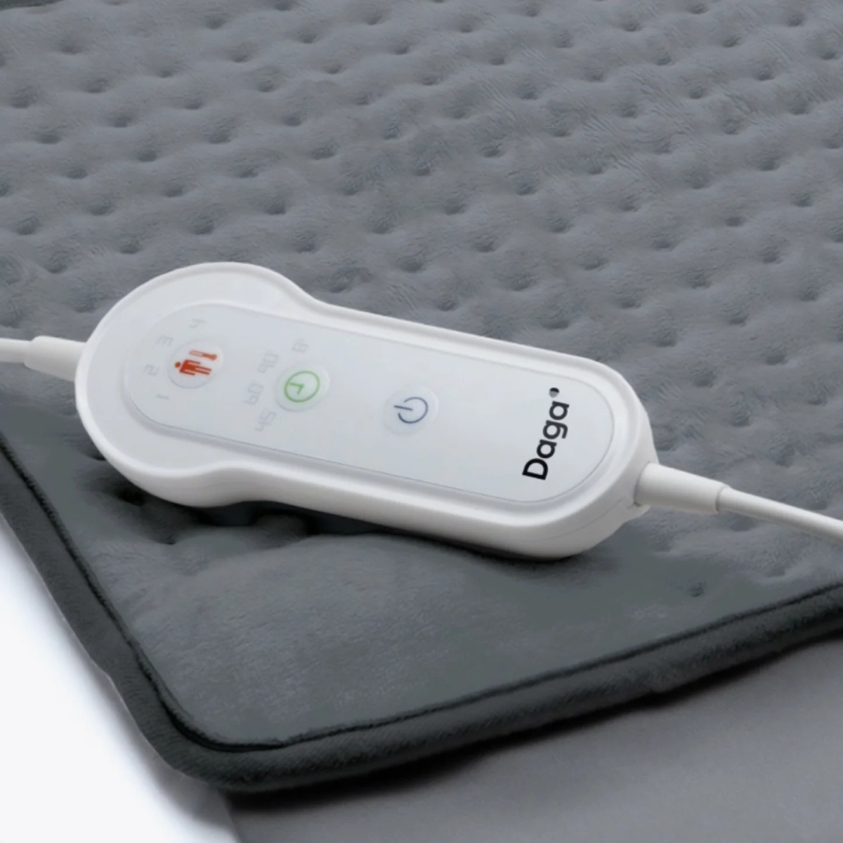 Manta térmica gris con controlador. Controlador blanco con botones y números.