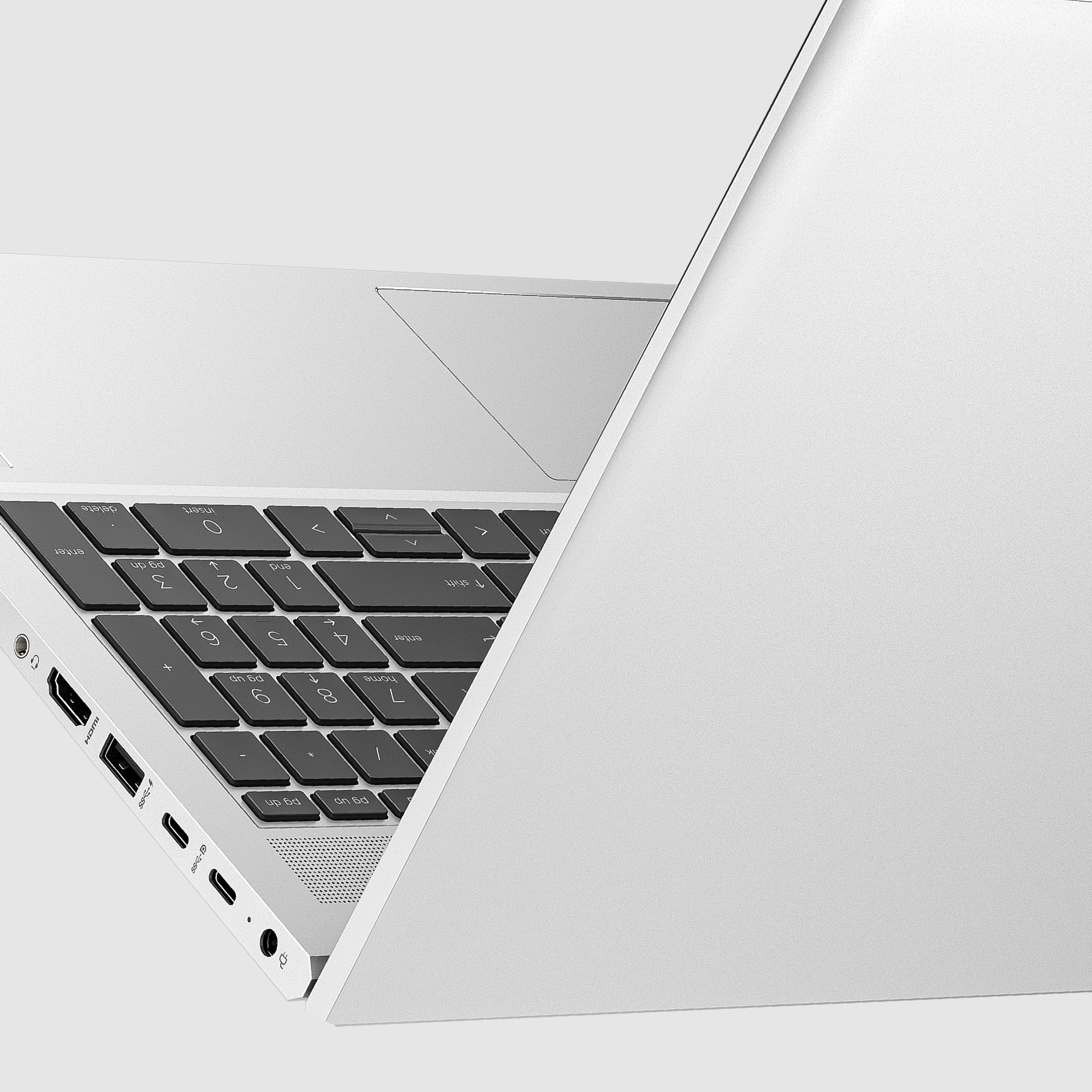 Un laptop con il coperchio aperto, tastiera visibile, su una superficie bianca.