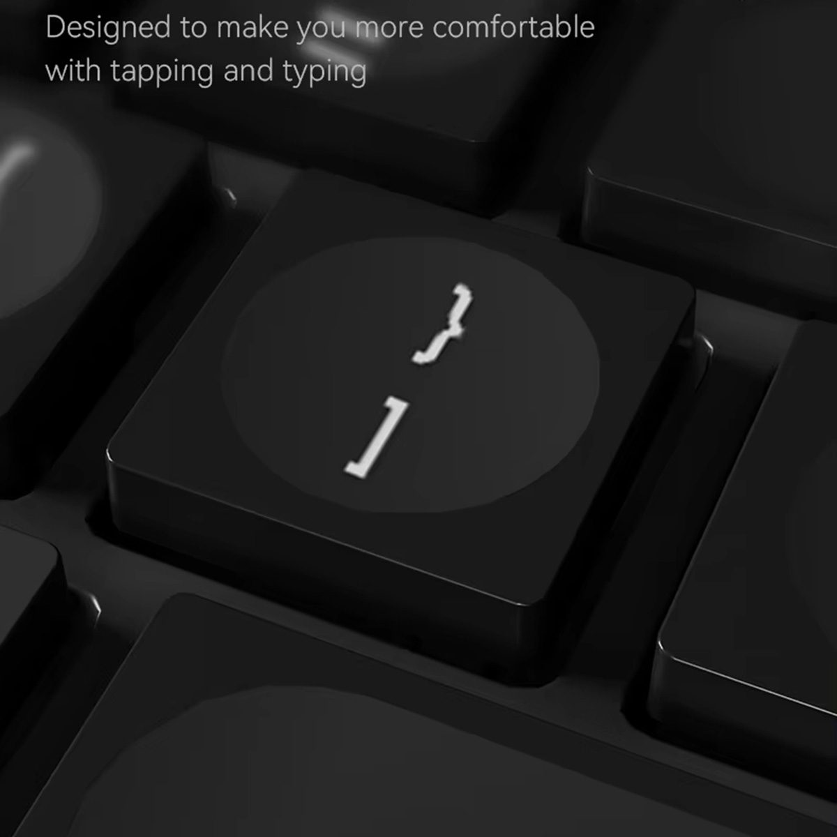 Primer plano de un teclado negro con llaves que muestran corchetes y una barra vertical.