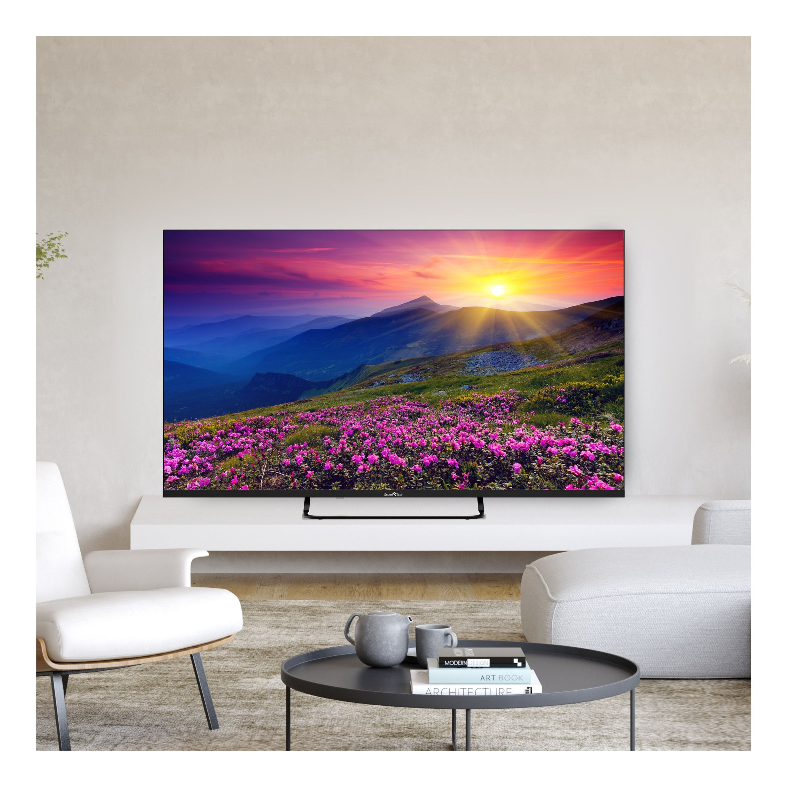 Un grande schermo TV mostra un tramonto sulle montagne con fiori. Tavolo e sedie di fronte.