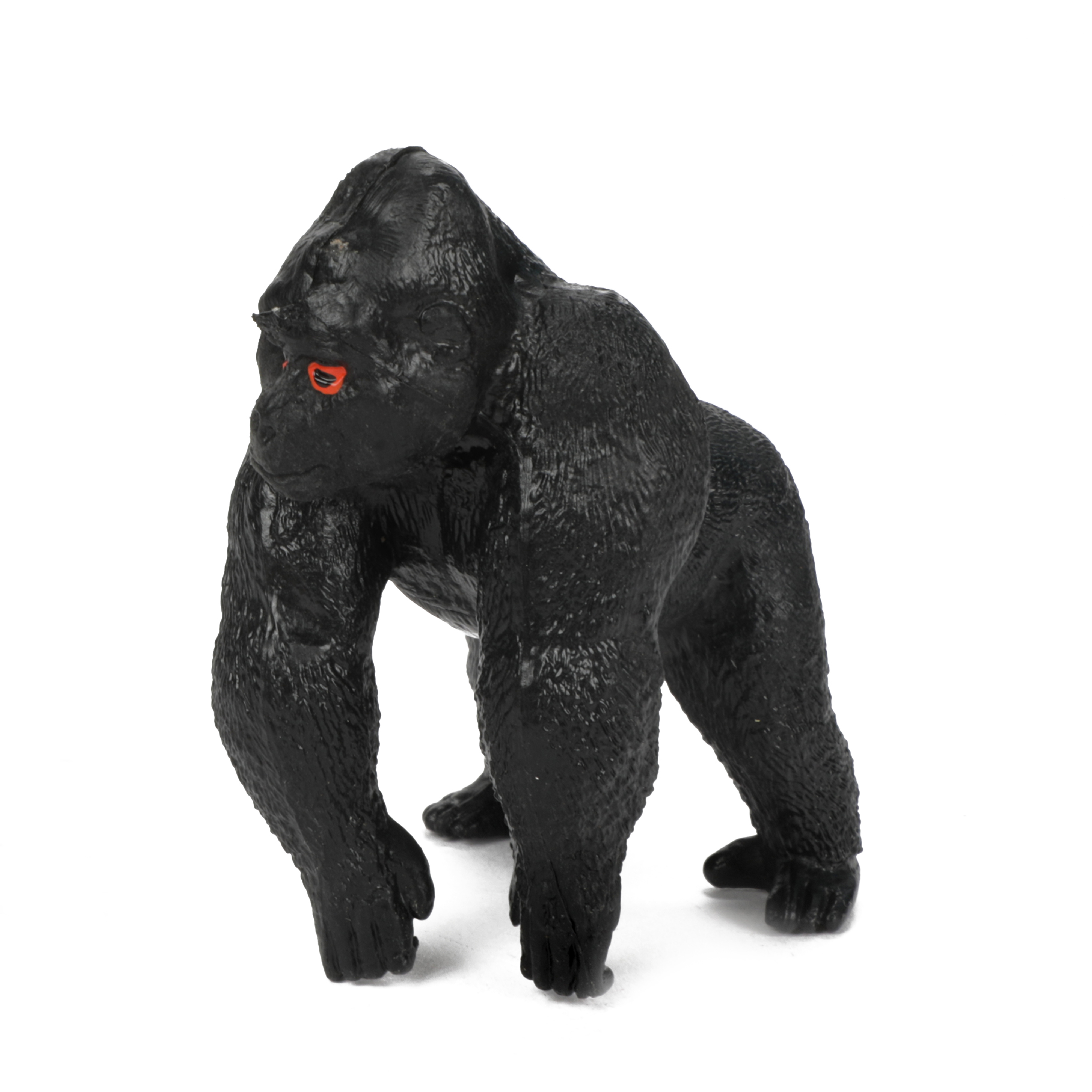 Schwarzes Gorilla-Spielzeug auf weißem Hintergrund. Der Gorilla steht aufrecht, nach vorne gerichtet.