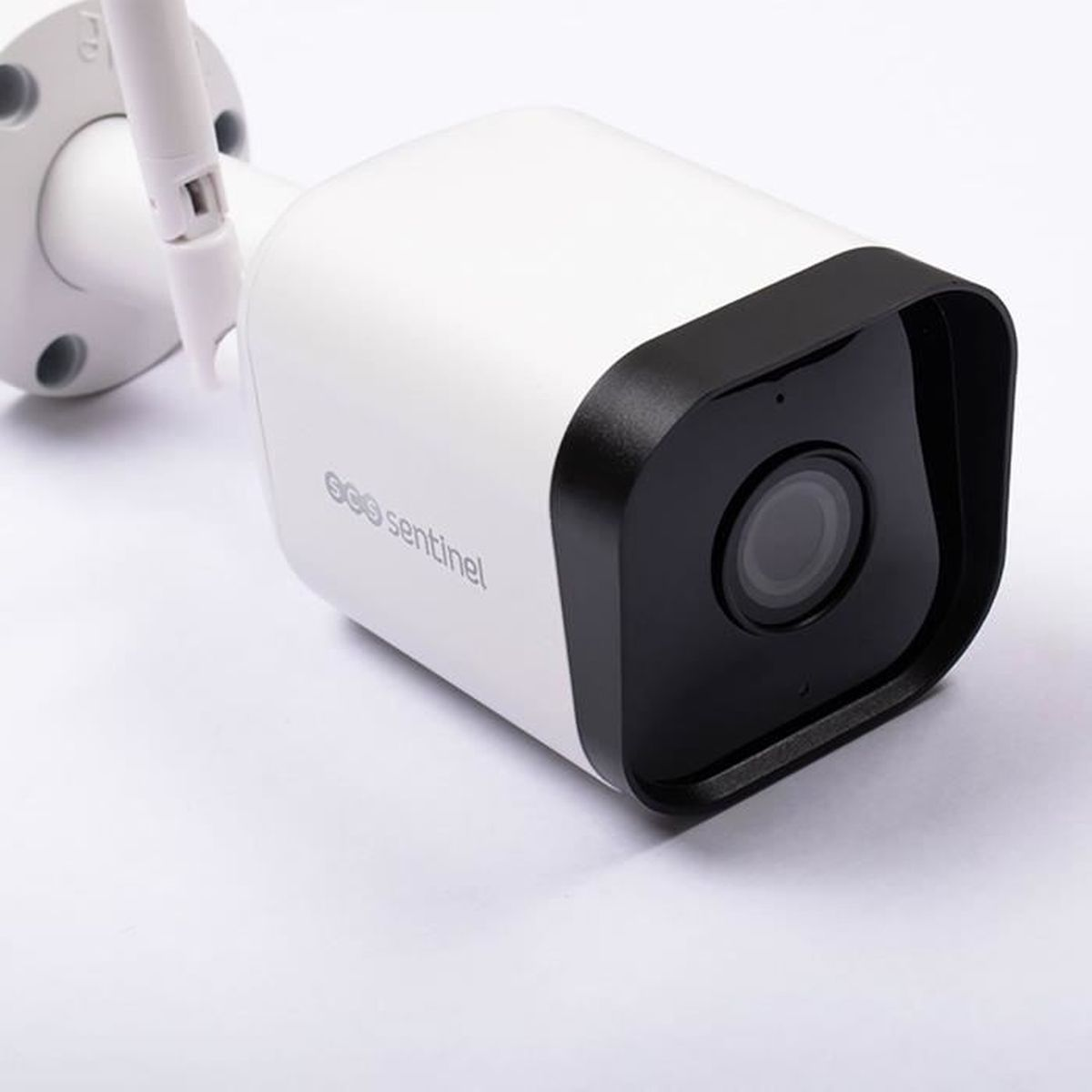 Telecamera di sicurezza bianca e nera con lente e antenna bianca su sfondo bianco.