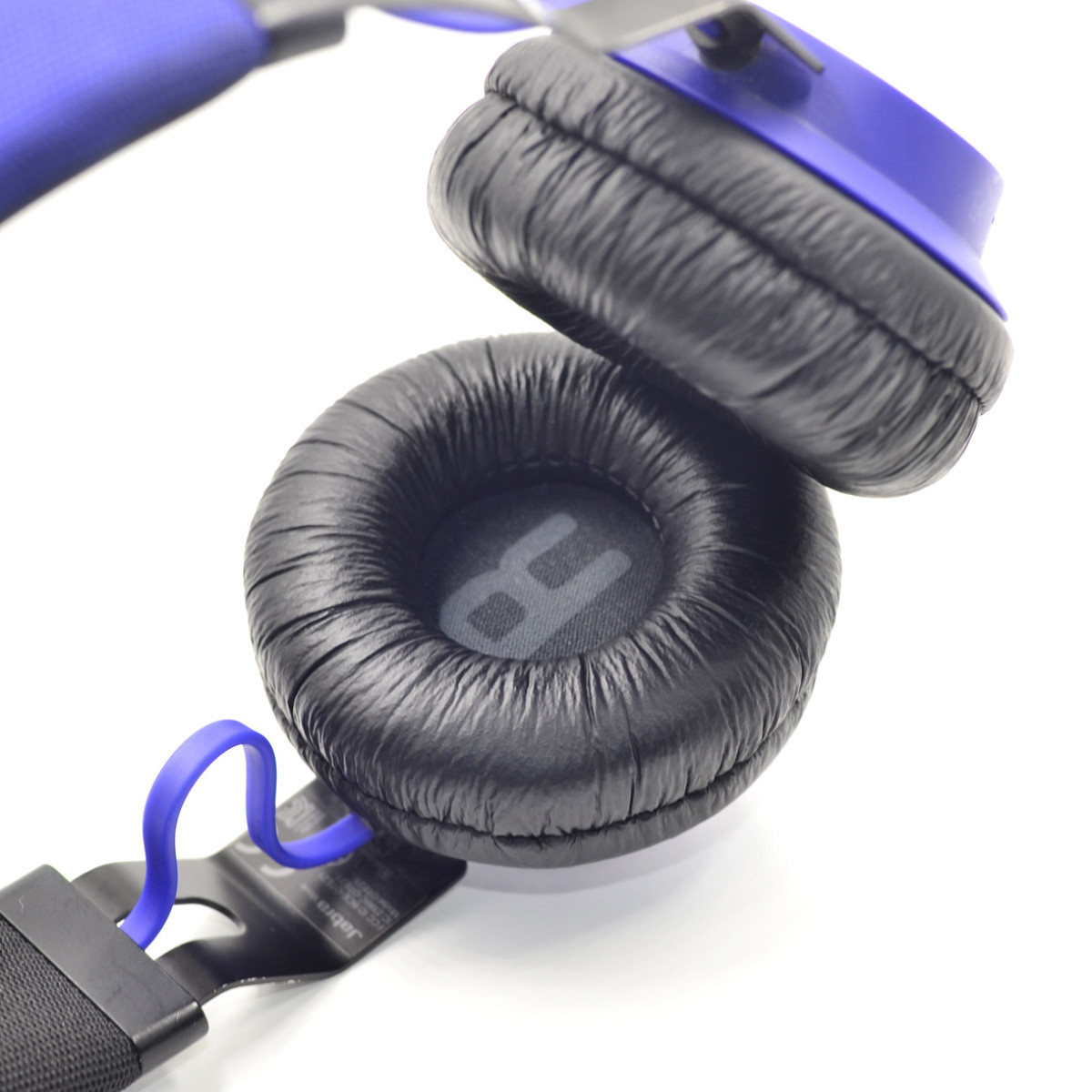 Blaue und schwarze Kopfhörer mit Ohrmuscheln, auf weißem Hintergrund, Nahaufnahme.