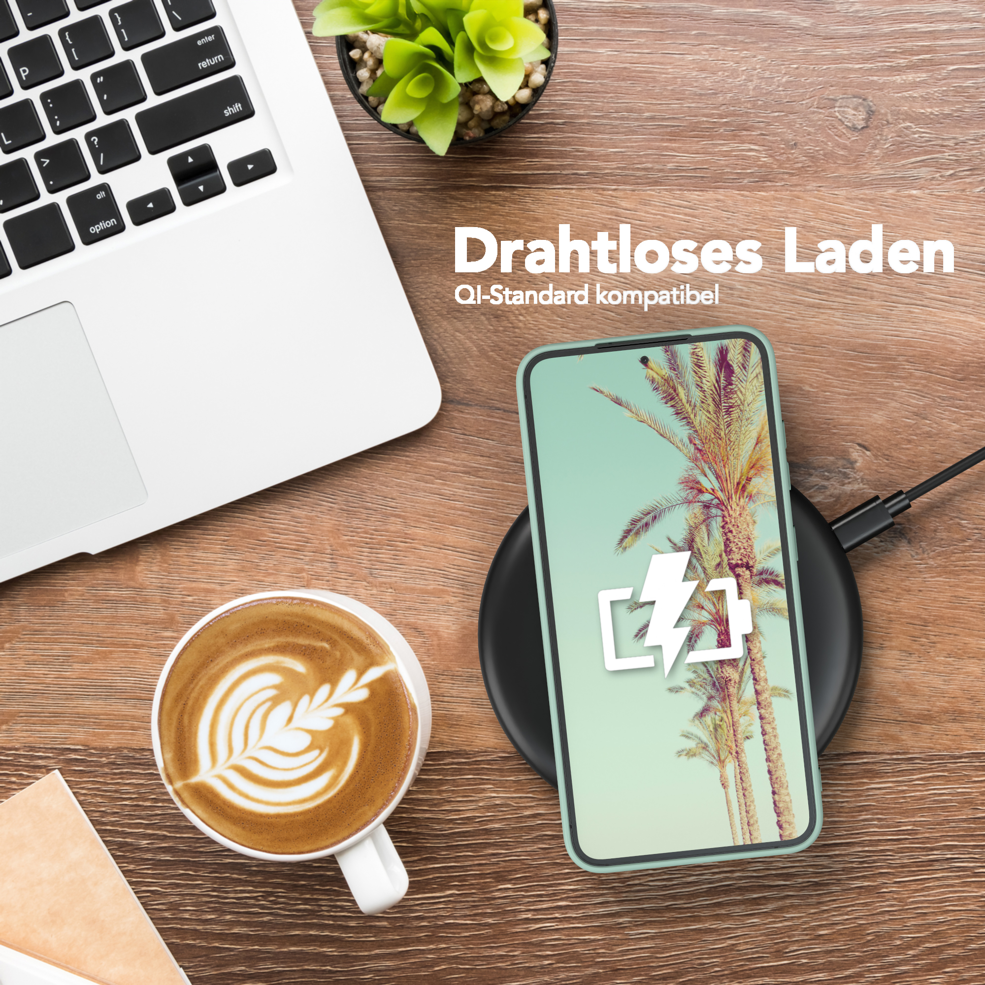 Kabelloses Laden eingerichtet. Telefon wird auf einem Pad geladen. Kaffee und Laptop sind vorhanden.