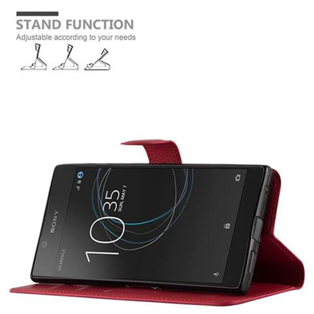 Eine rote Handyhülle mit einem Handy darin, das aufrecht steht. Das Handy zeigt eine Uhr an. Die Hülle hat eine Ständerfunktion.