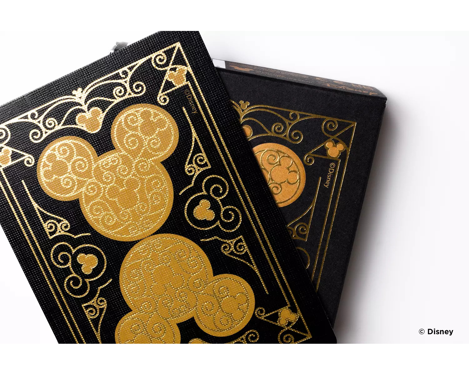 Zwei schwarze Notizbücher im Disney-Design mit goldenen Mickey Mouse-Designs auf weißem Hintergrund.