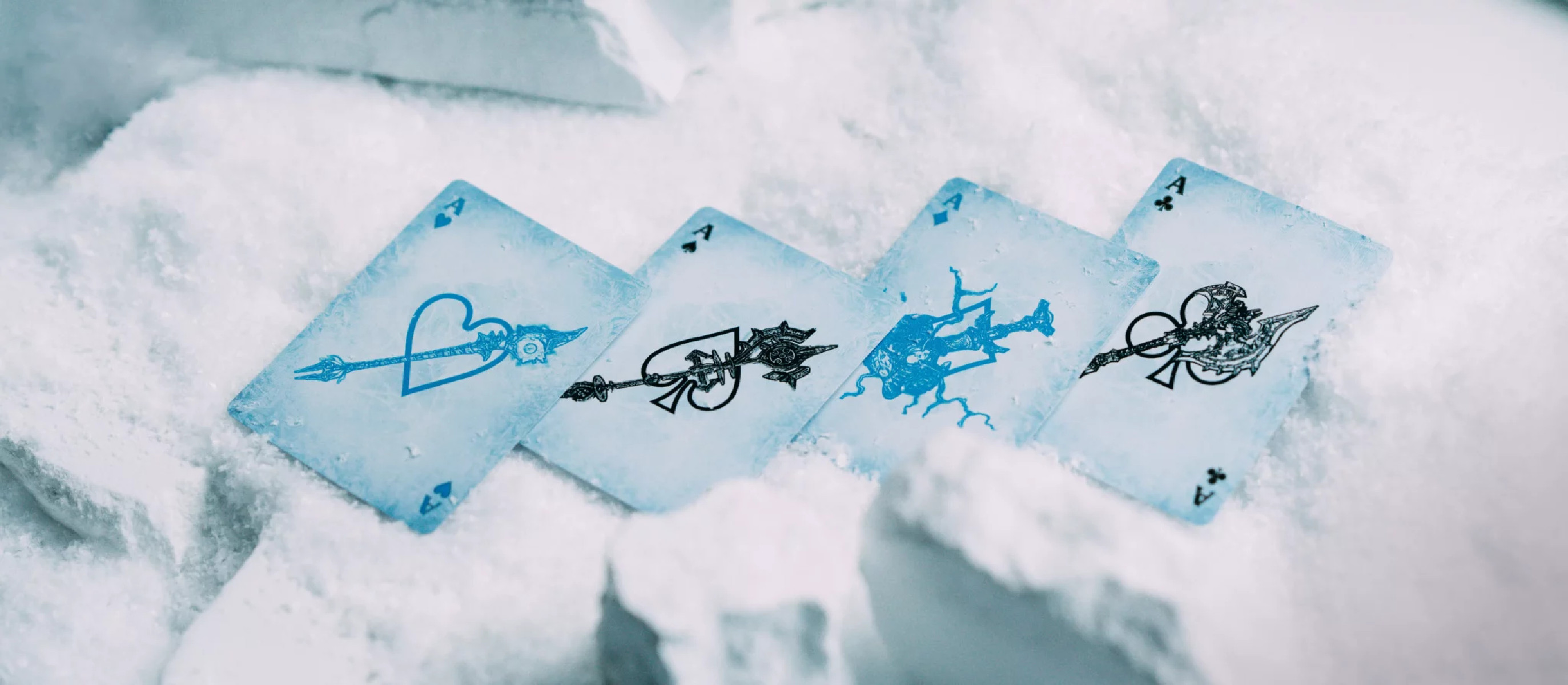 Vier Asse auf Schnee. Herz, Pik, Kreuz und Karo sind auf den Karten abgebildet.