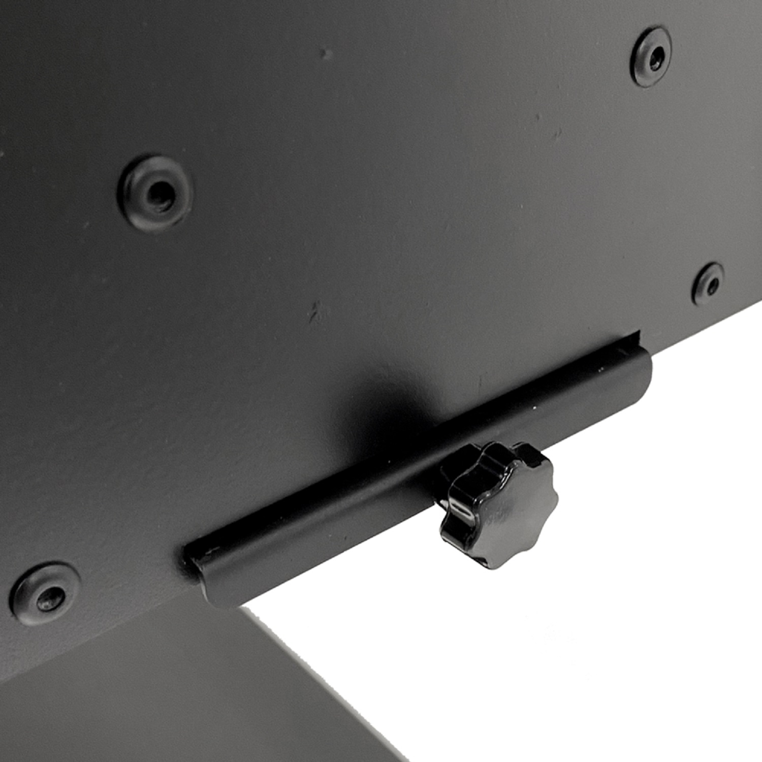 Eine schwarze Metallstruktur mit Schrauben. Unten befindet sich ein schwarzer Knopf, der nach links abgewinkelt ist.