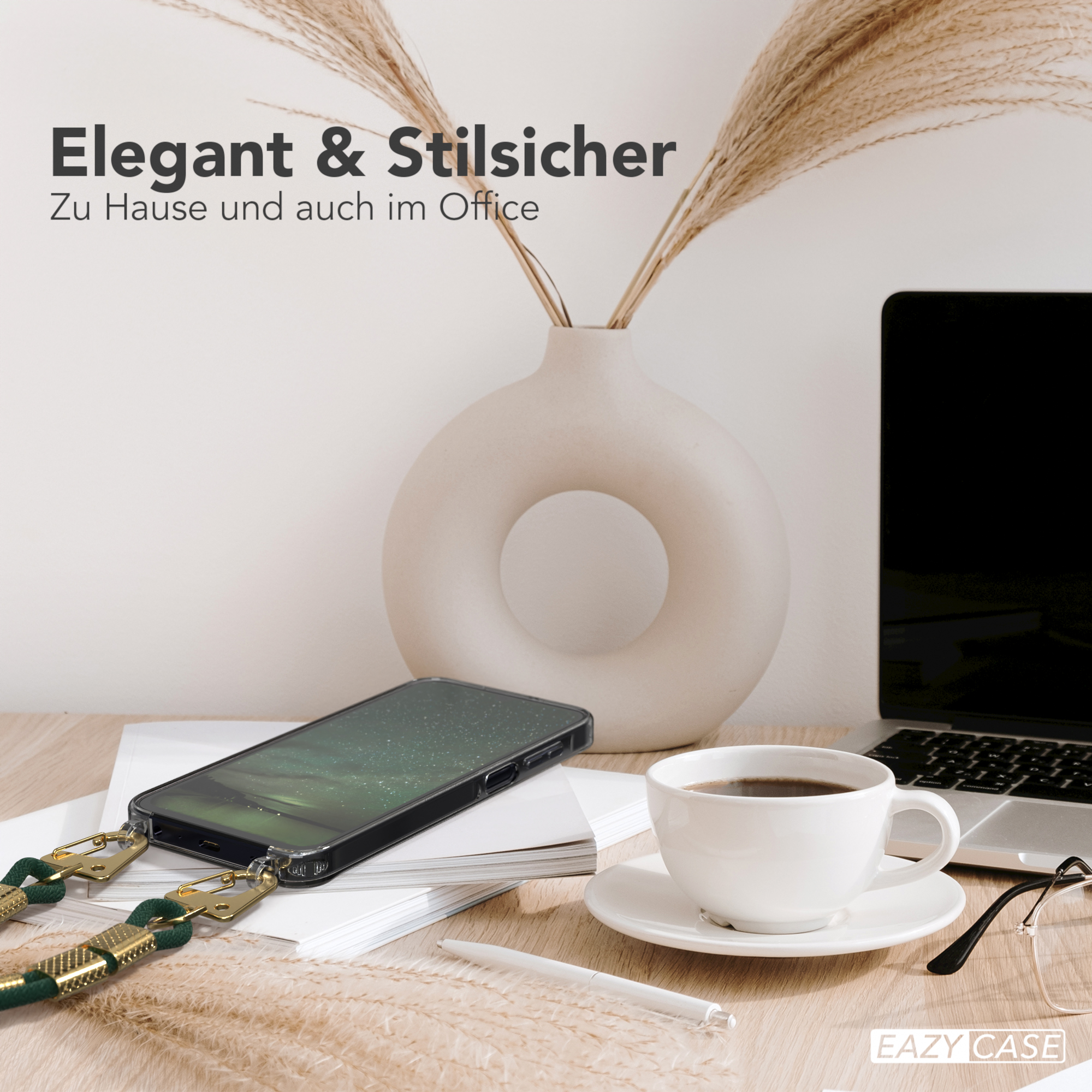 Smartphone mit Hülle und Lanyard, in der Nähe von Laptop, Kaffee und Blumen.