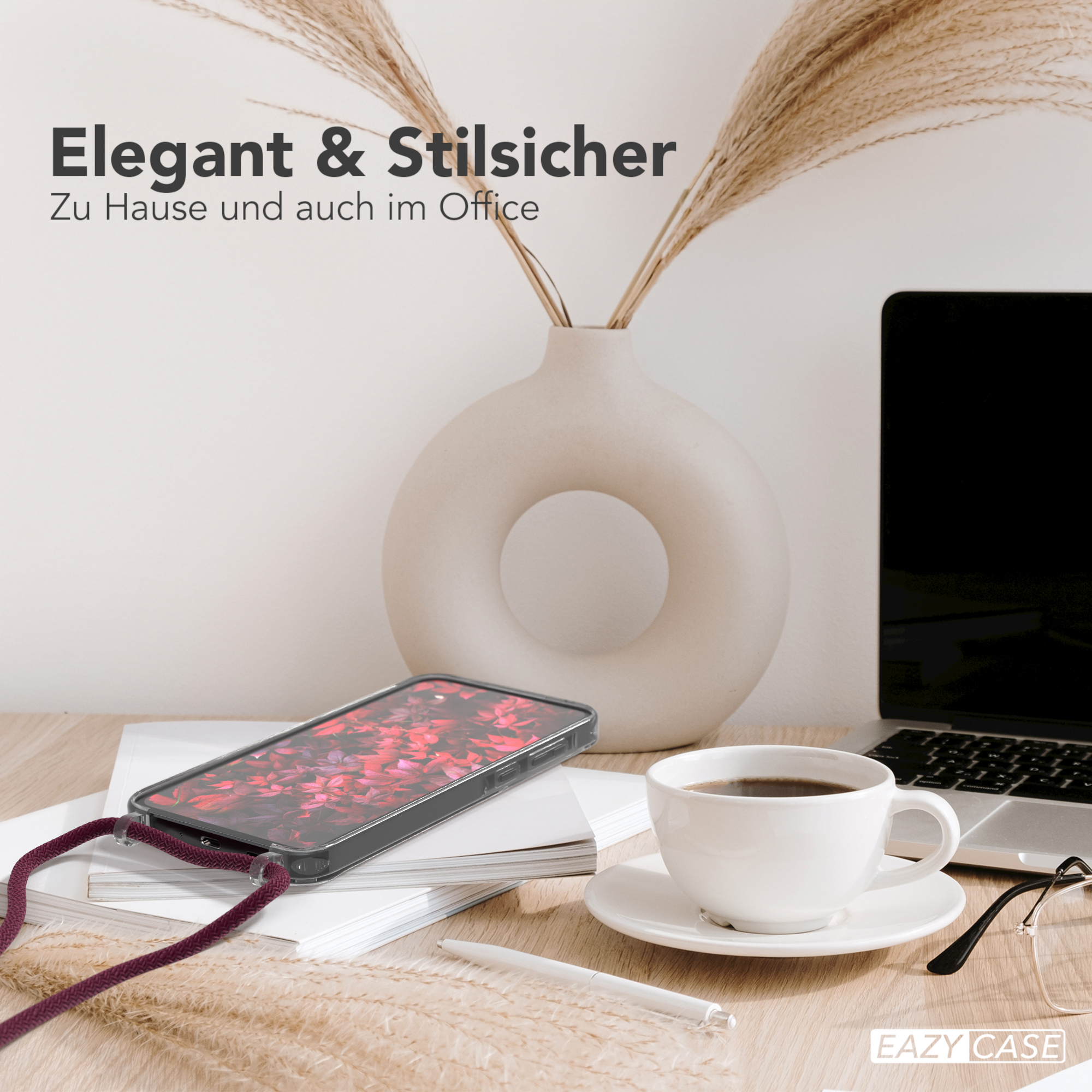 Telefon mit roter Blumenhülle, Kaffee, Vase mit Weizen und Laptop auf einem Holztisch.