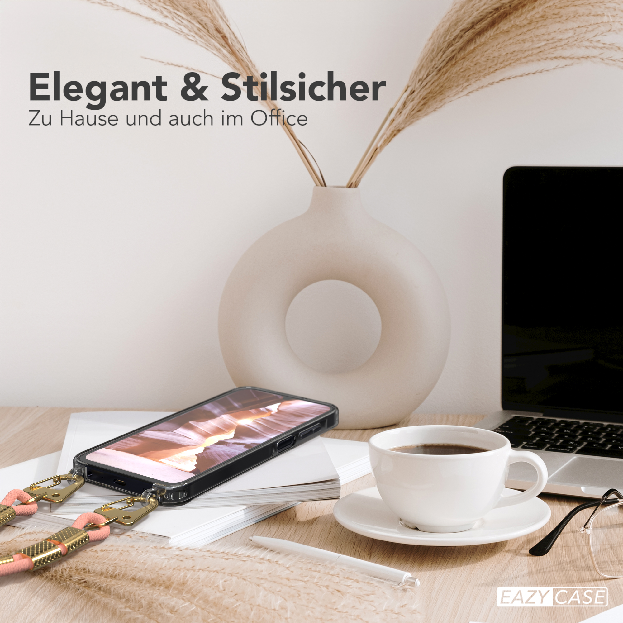 Moderne Büro-Schreibtisch-Setup. Beinhaltet eine Handyhülle mit Riemen, einen Laptop und eine Kaffeetasse.