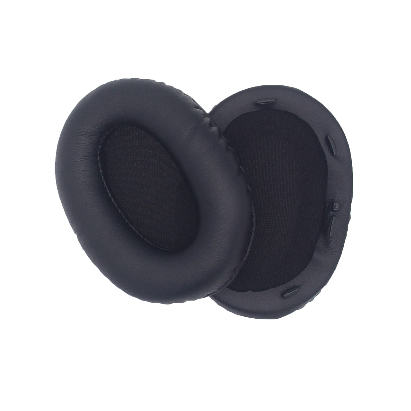 Dwie czarne poduszki na uszy, odizolowane na białym tle. Jedna jest lekko nachylona nad drugą.