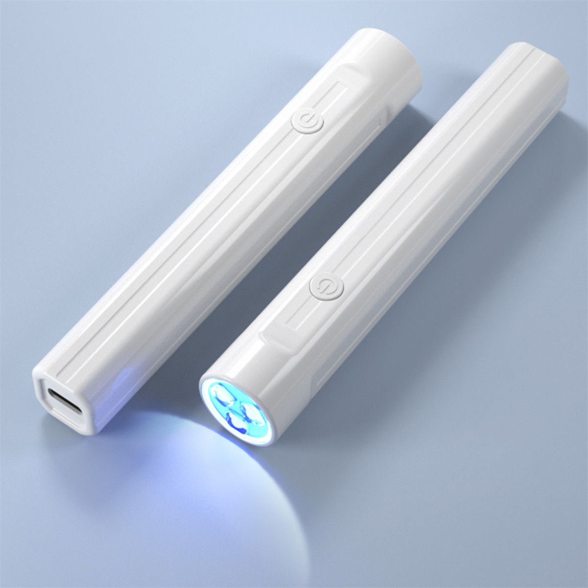 Zwei weiße Taschenlampen, von denen eine blaues Licht aussendet, vor blauem Hintergrund.