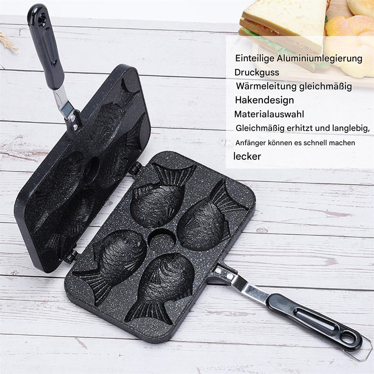 Geöffnete, schwarze, fischförmige Kochpfanne. Details umfassen Fischformen, Griffe und Text.