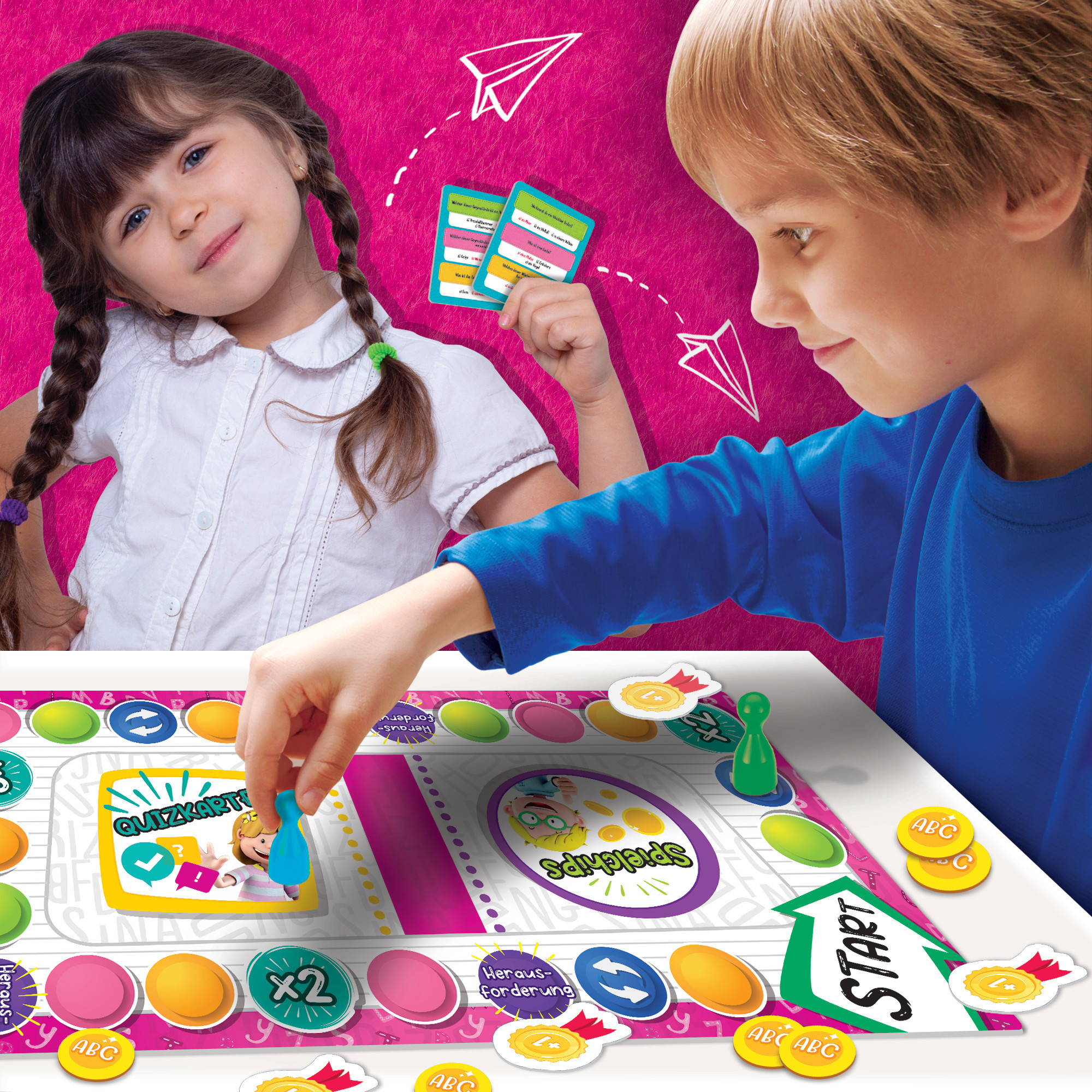 Zwei Kinder spielen ein Brettspiel mit Karten und Spielsteinen auf weißer Oberfläche.