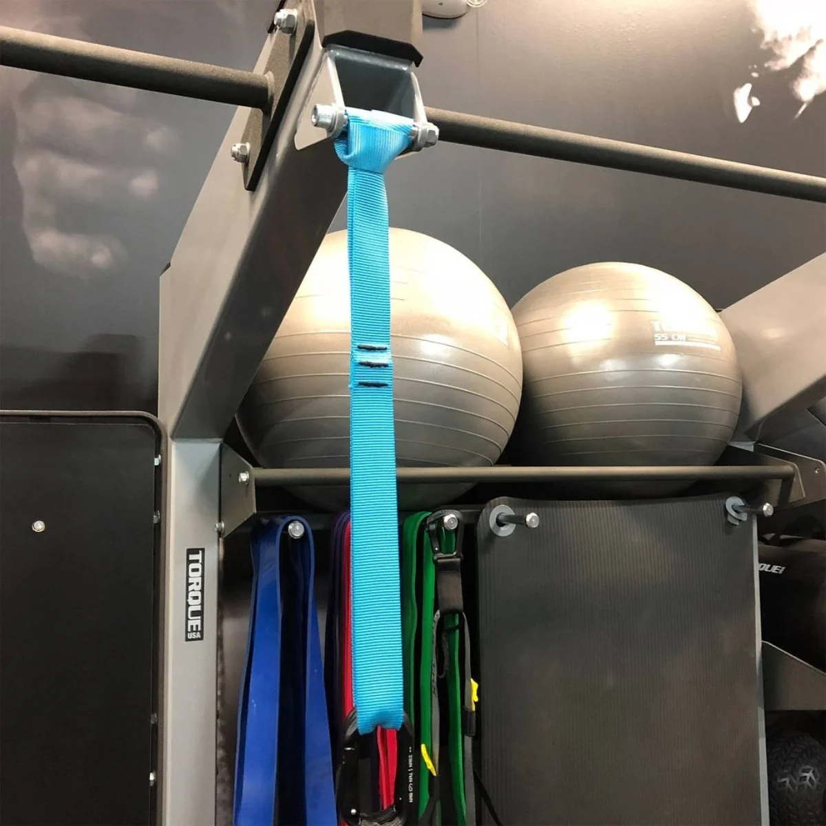 Eine Fitness-Trainingsstruktur mit Gymnastikbällen und hängenden Riemen, in einem Fitnessstudio.