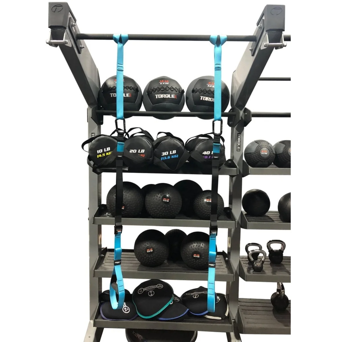 Fitnessgeräte-Regal mit Medizinbällen, Kettlebells und Gurten. Verschiedene Gewichte und Größen.