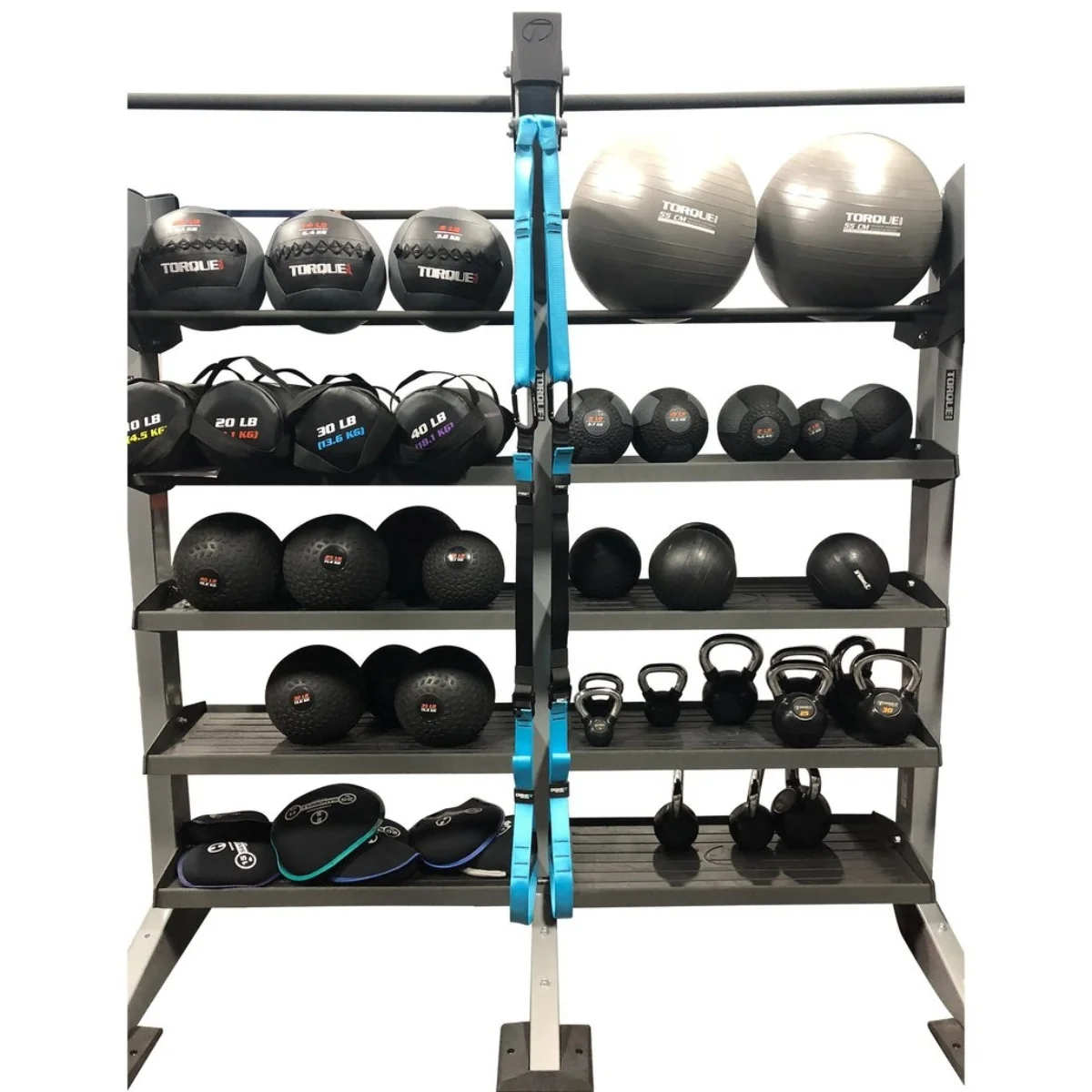 Fitnessgeräte in Regalen. Gewichte, Bälle und anderes Zubehör sind sichtbar. Grau und blau.