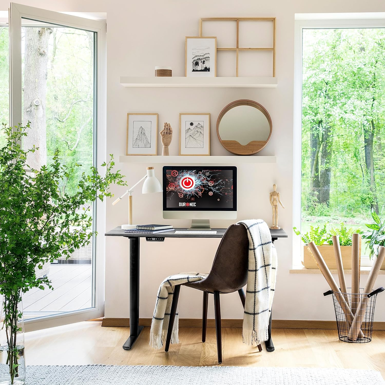 Schreibtisch mit Computer, Stuhl, Deko in hellem Raum mit Fenstern.