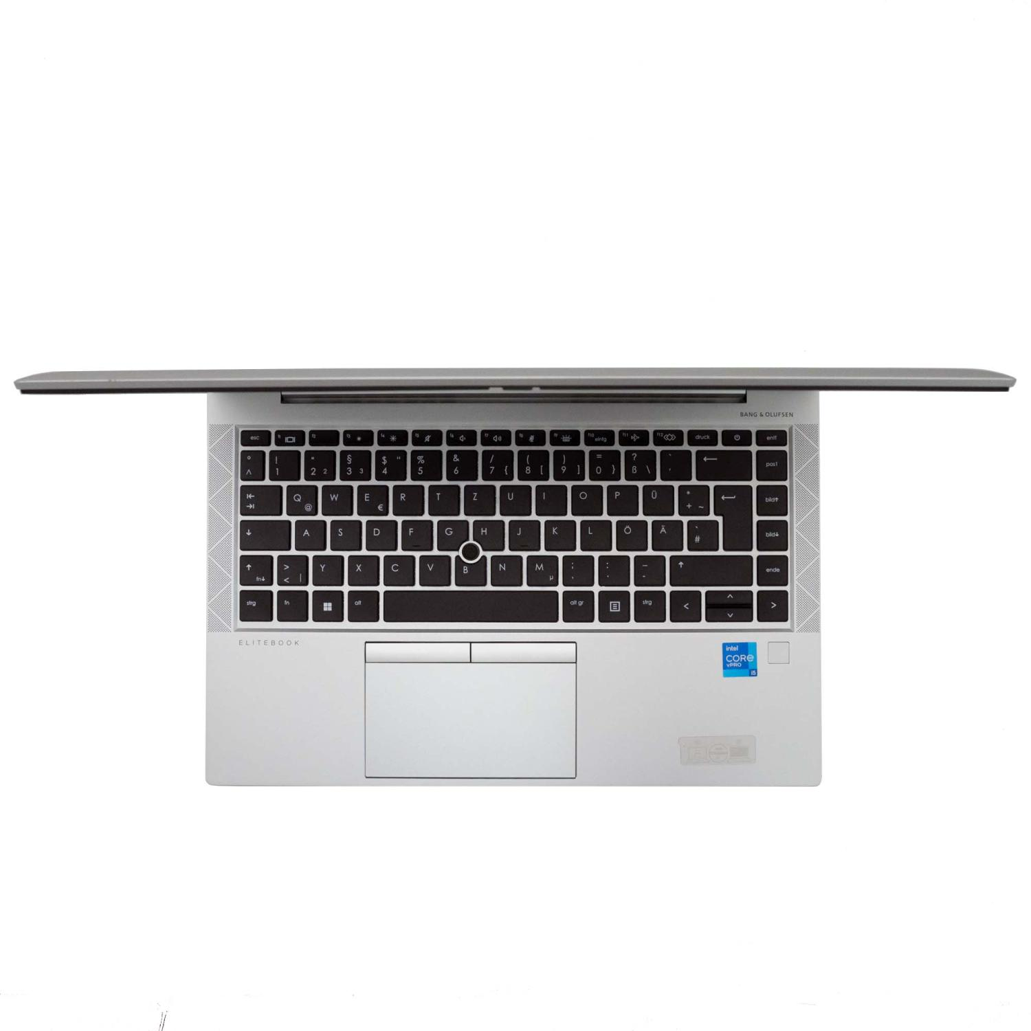 Draufsicht auf einen silbernen Laptop mit geöffnetem Bildschirm, der Tastatur und Touchpad zeigt.