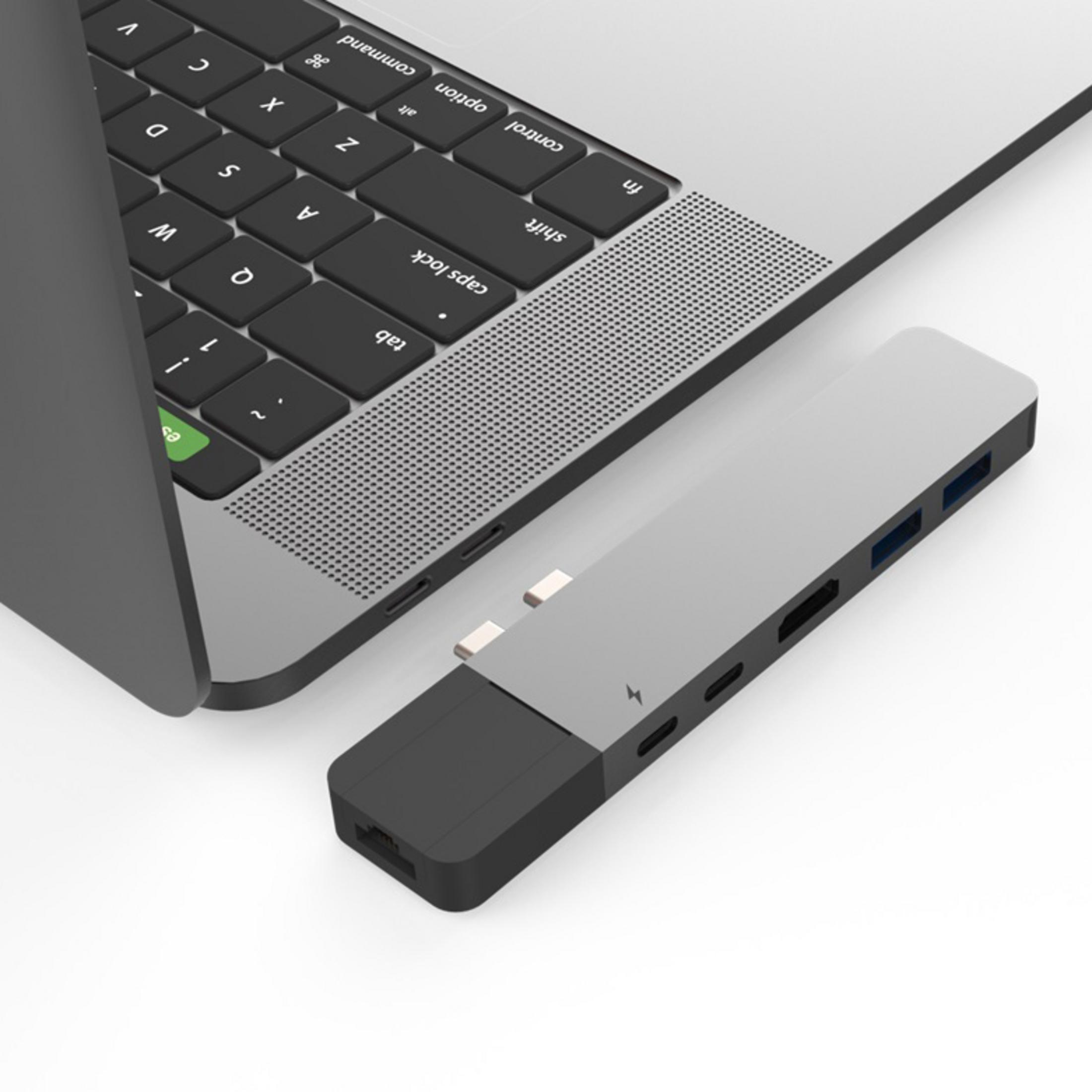 Laptop mit angeschlossenem Hub. Der Hub hat mehrere Anschlüsse: USB, HDMI und andere.