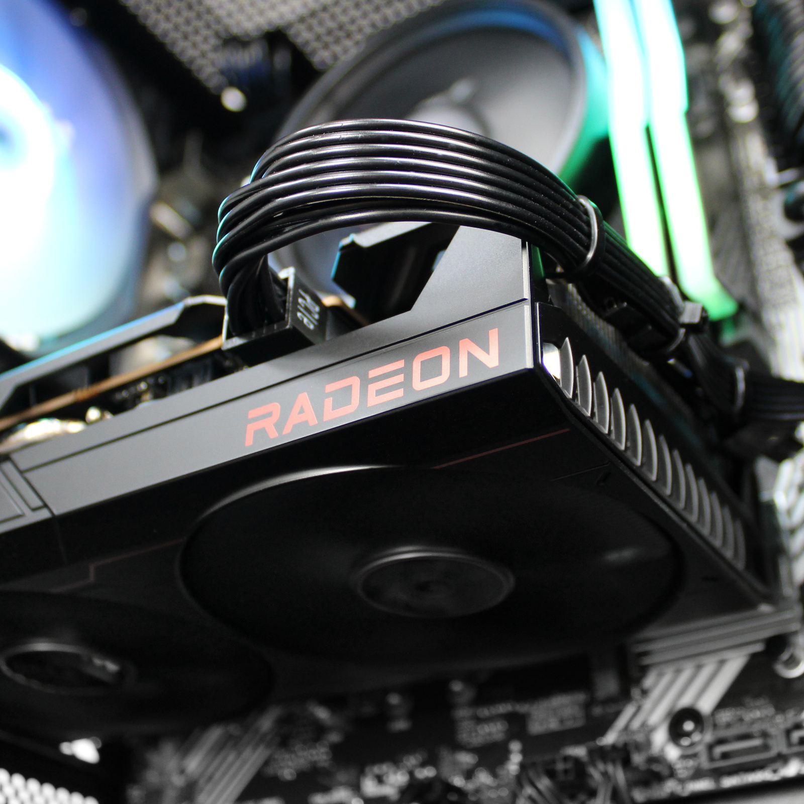 Tarjeta gráfica con texto RADEON, diseño negro y rojo, ventilador.