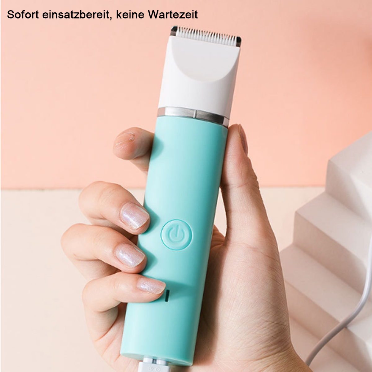 Ein mintgrüner Haarschneider wird von einer Hand gehalten. Der Trimmer hat einen Ein-/Ausschalter.