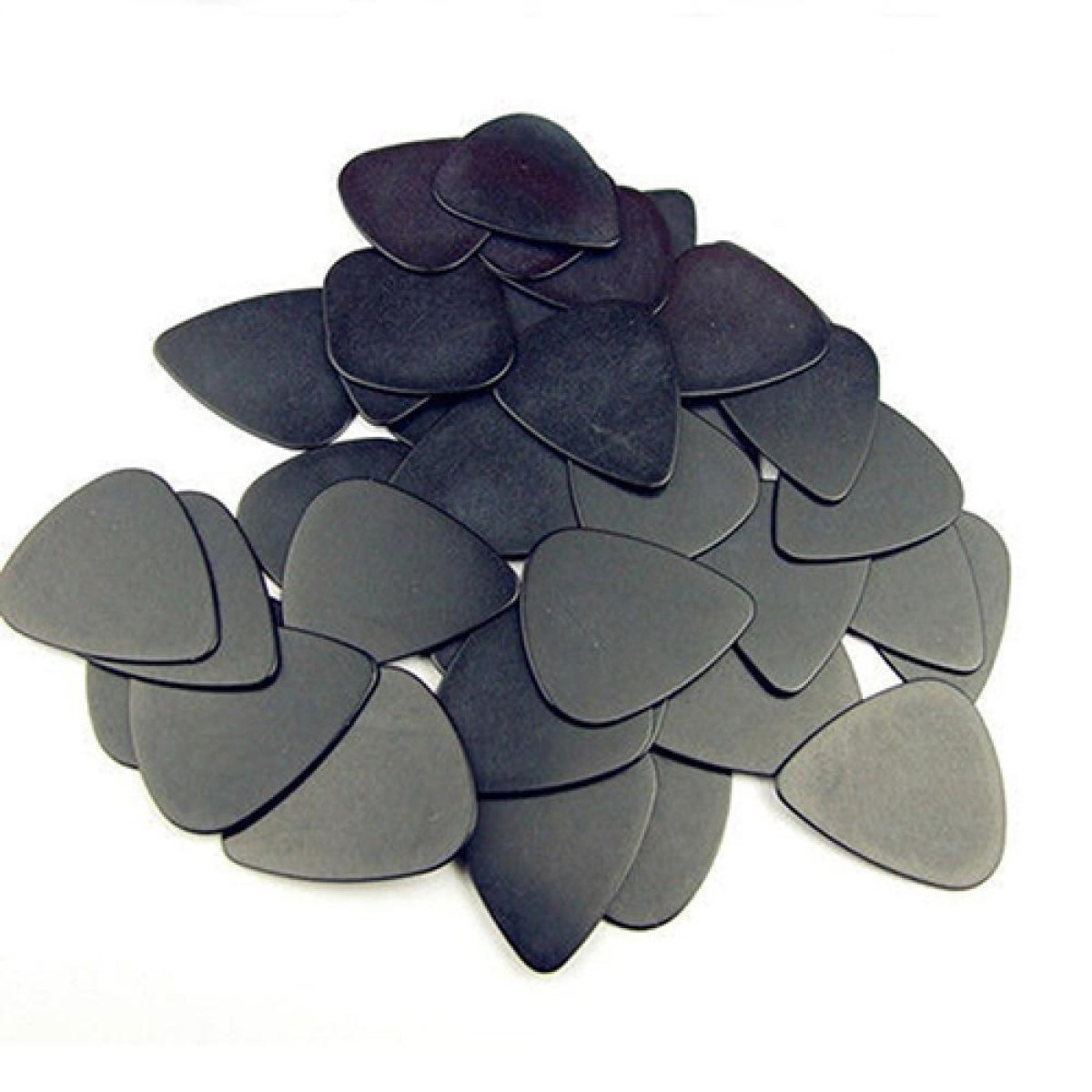 Eine Sammlung schwarzer Gitarrenplektren auf einer weißen Oberfläche verstreut.