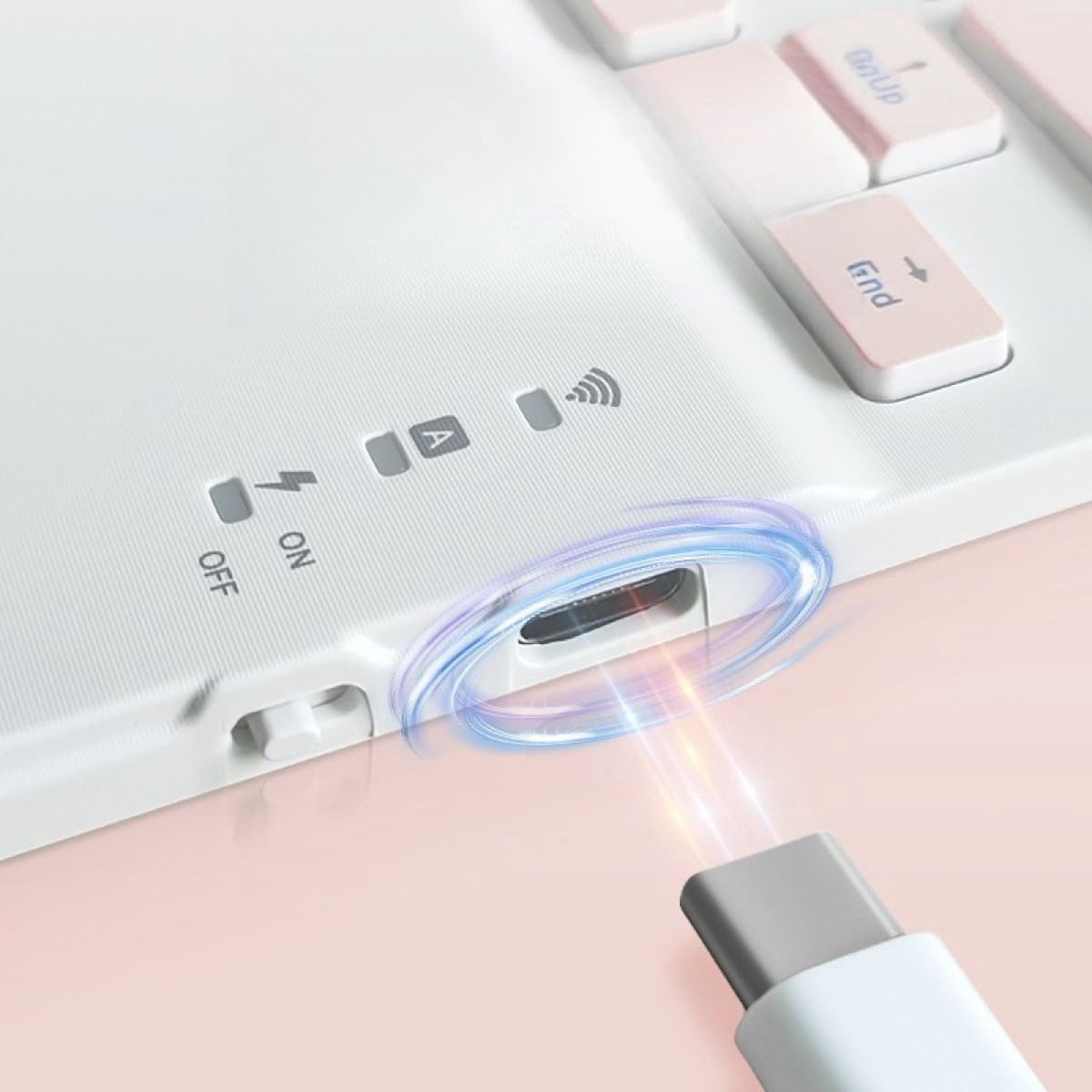 Tastiera bianca con tasti rosa, una porta di ricarica e un cavo USB-C collegato.