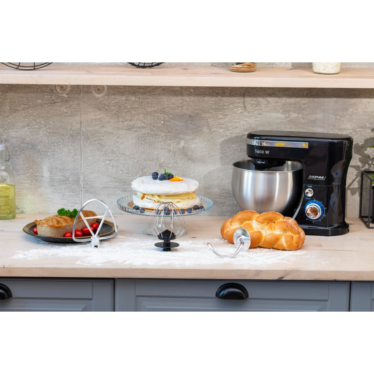 Kuchnia z czarnym mikserem stojącym, ciastem, chlebem i różnymi narzędziami do pieczenia.