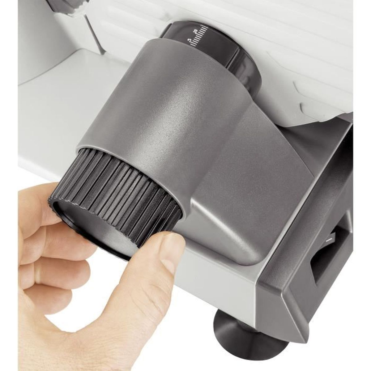 Zbliżenie szarej krajalnicy, z dłonią regulującą kontrolę grubości.