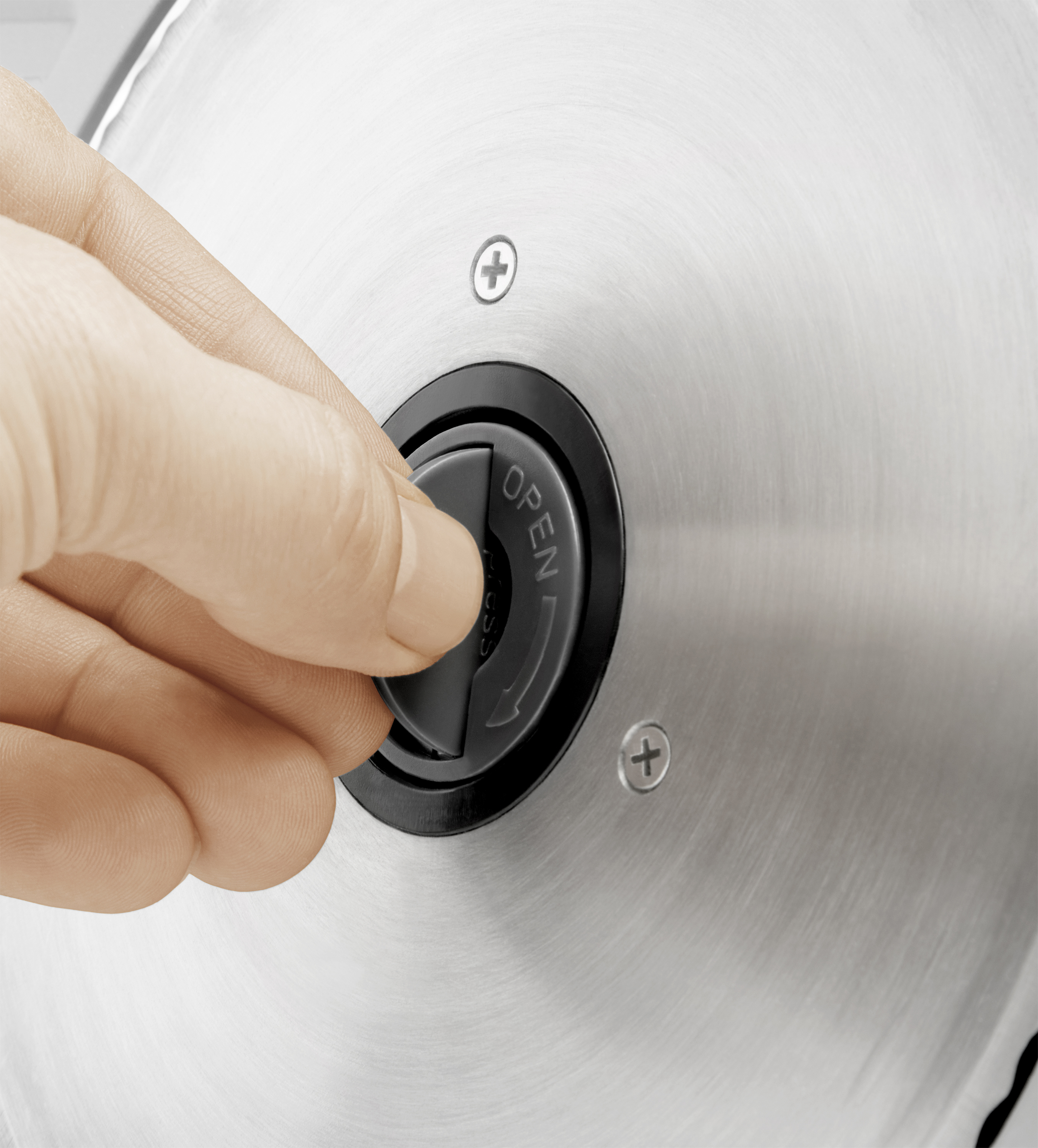 Ręka obraca czarne pokrętło na metalowym urządzeniu, oznaczone napisem 'OPEN'.