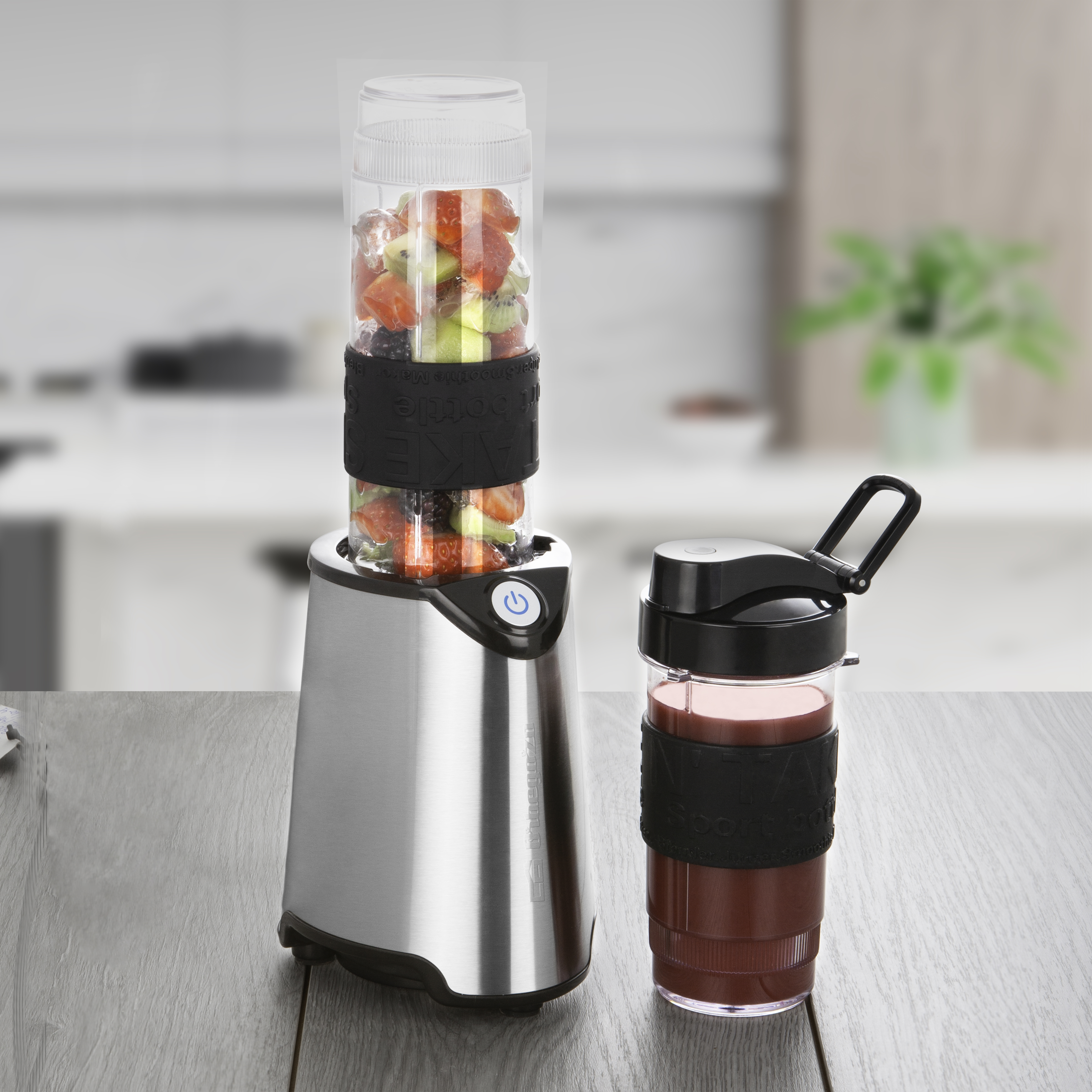 Licuadora con fruta y vaso de batido. Fondo de cocina.