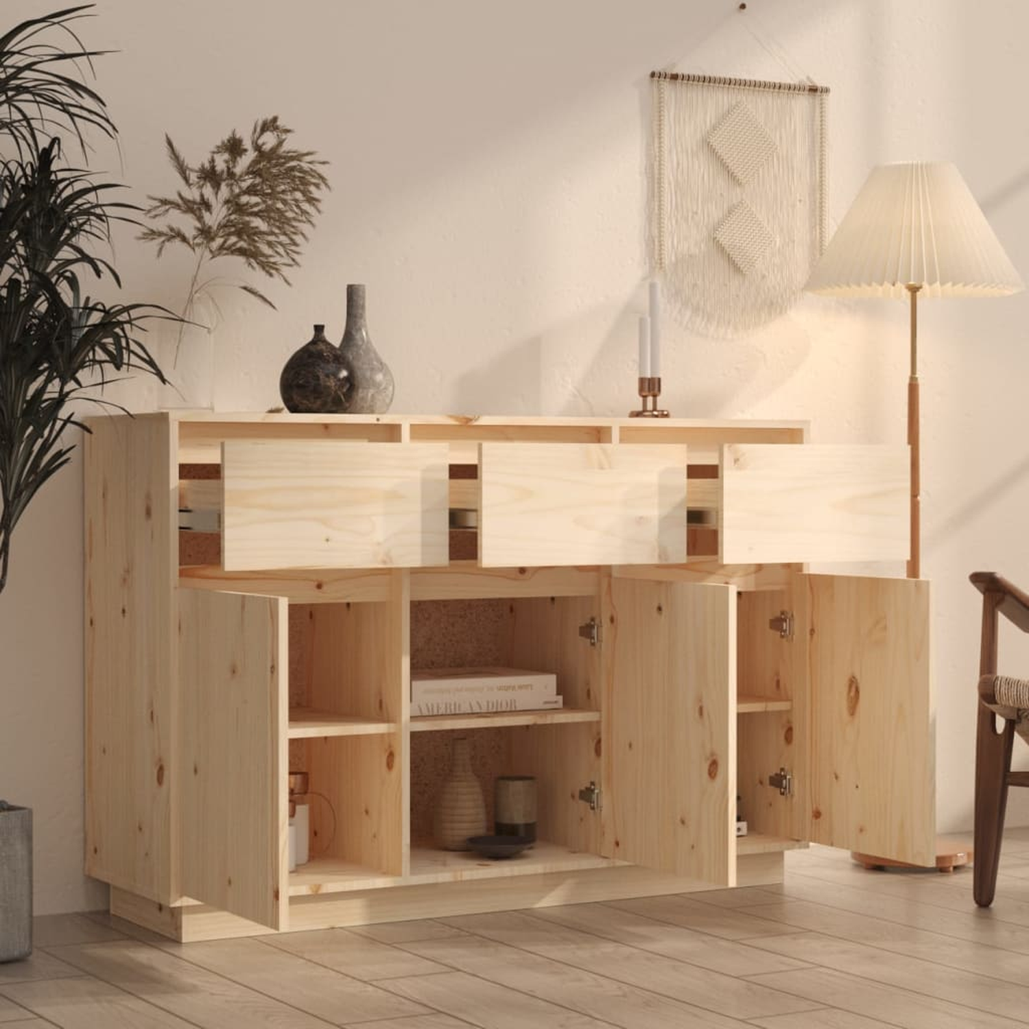Holzsideboard mit offenen Türen und Schubladen. Zeigt Bücher, Vasen und Deko mit Pflanzen und einer Lampe.