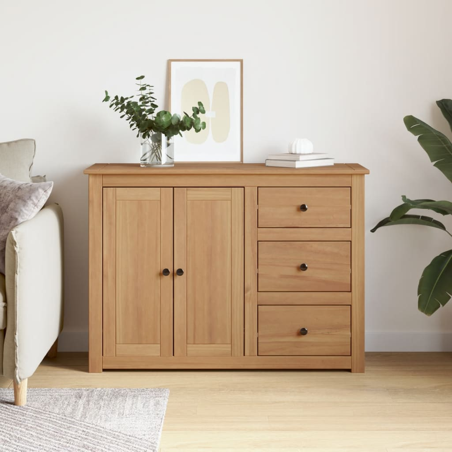 Holzschrank mit Türen und Schubladen. Eine Vase mit Pflanzen und ein Bilderrahmen obenauf.