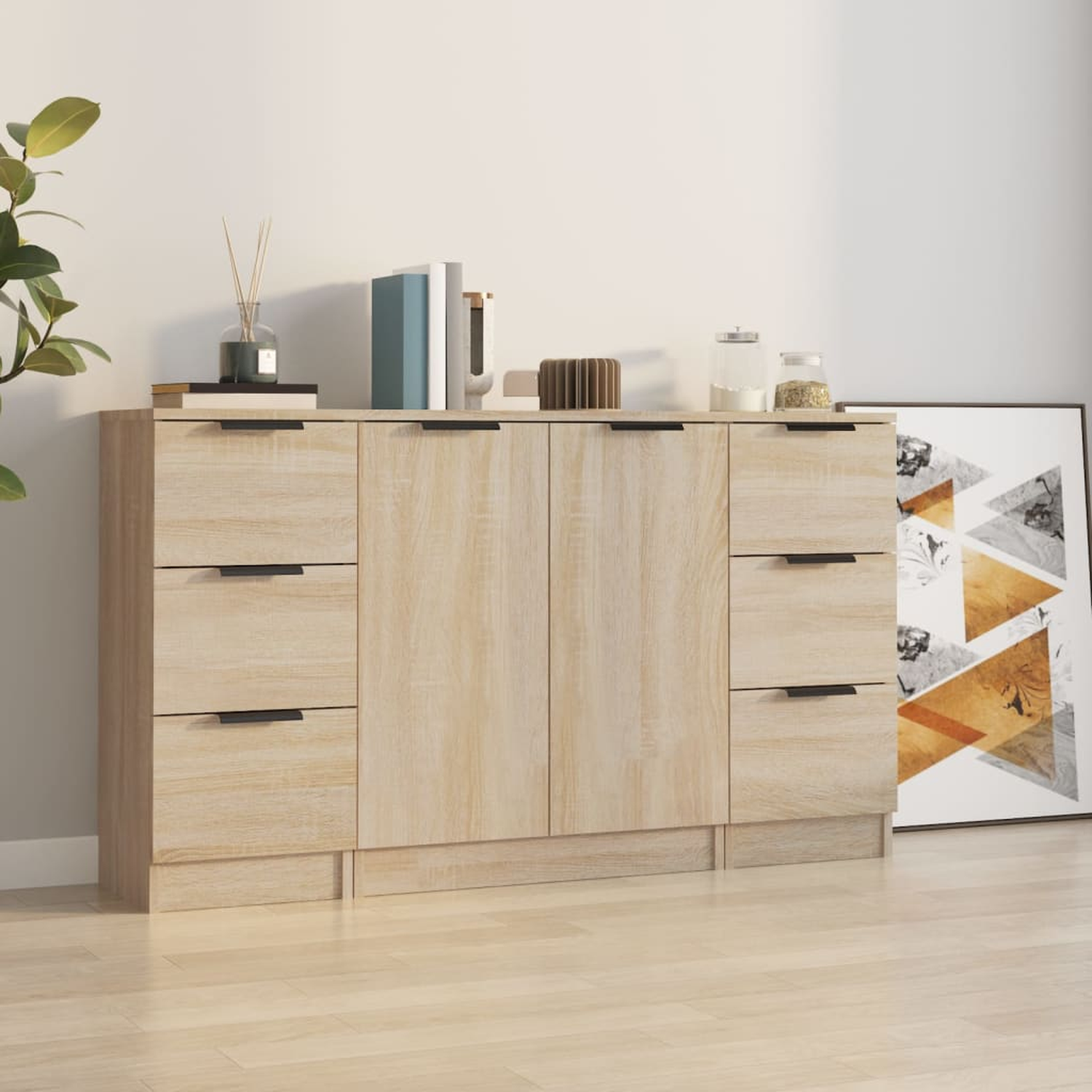 Holzschrank mit Schubladen und Türen. Bücher, Gläser und Deko oben. Eine Pflanze im Hintergrund.