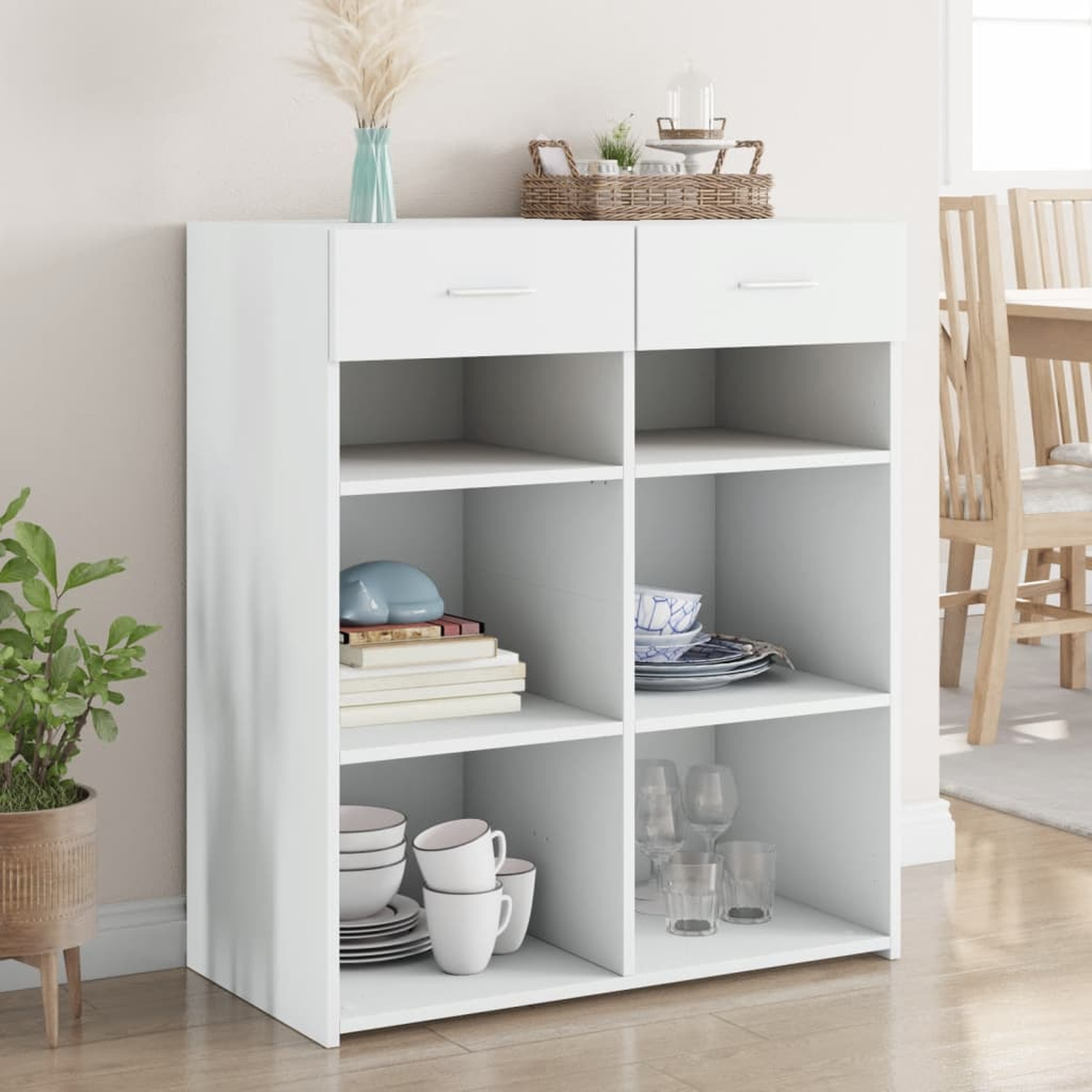 Weißer Schrank mit Regalen und Schubladen. Er hat Dekoration, Geschirr und Gläser.