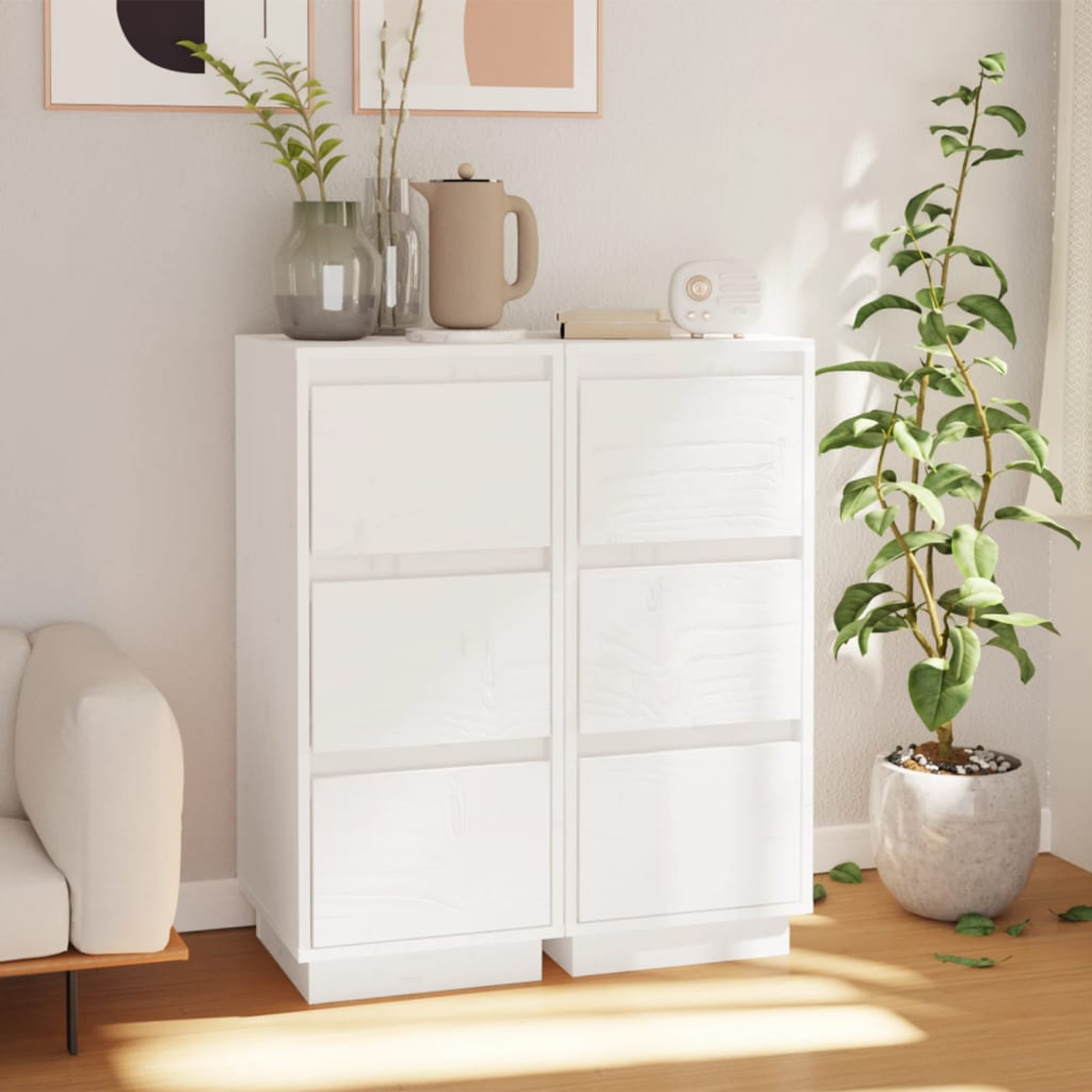 Weißer Schrank mit Schubladen und Türen. Vasen und Pflanze oben. Modernes Design.