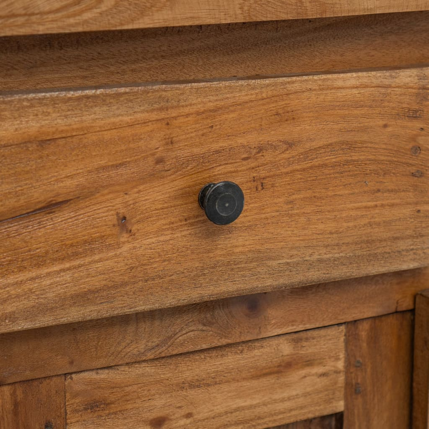 Nahaufnahme einer Holzschublade mit einem schwarzen Knopf.
