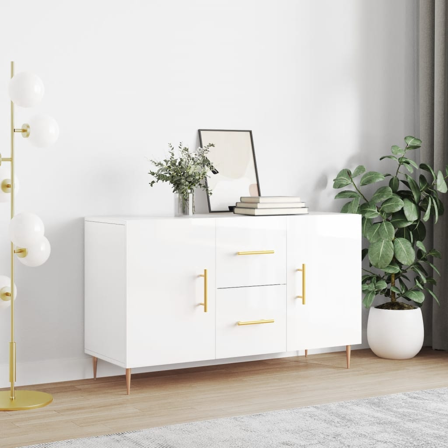 Ein weißer Schrank mit goldenen Griffen, eine Stehlampe, ein Gemälde und eine Pflanze in einem weißen Topf.